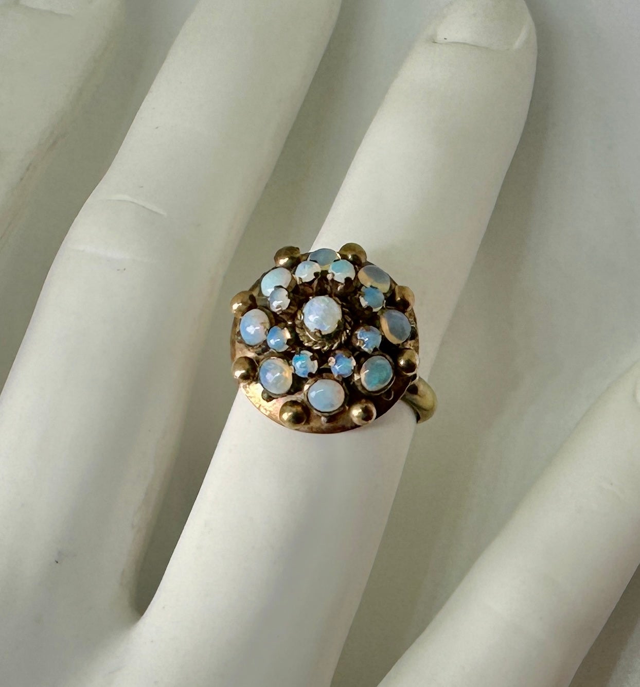 INDULGE IN A WONDERFUL ART DECO OPAL PRINCESS RING IN 14 KARAT GOLD OF GREAT BEAUTY.
The wonderful opal ring is a tall bombe princess ring.  It is set with 17 magnificent opals in two graduating halos ascending to the top of the ring.  The effect of