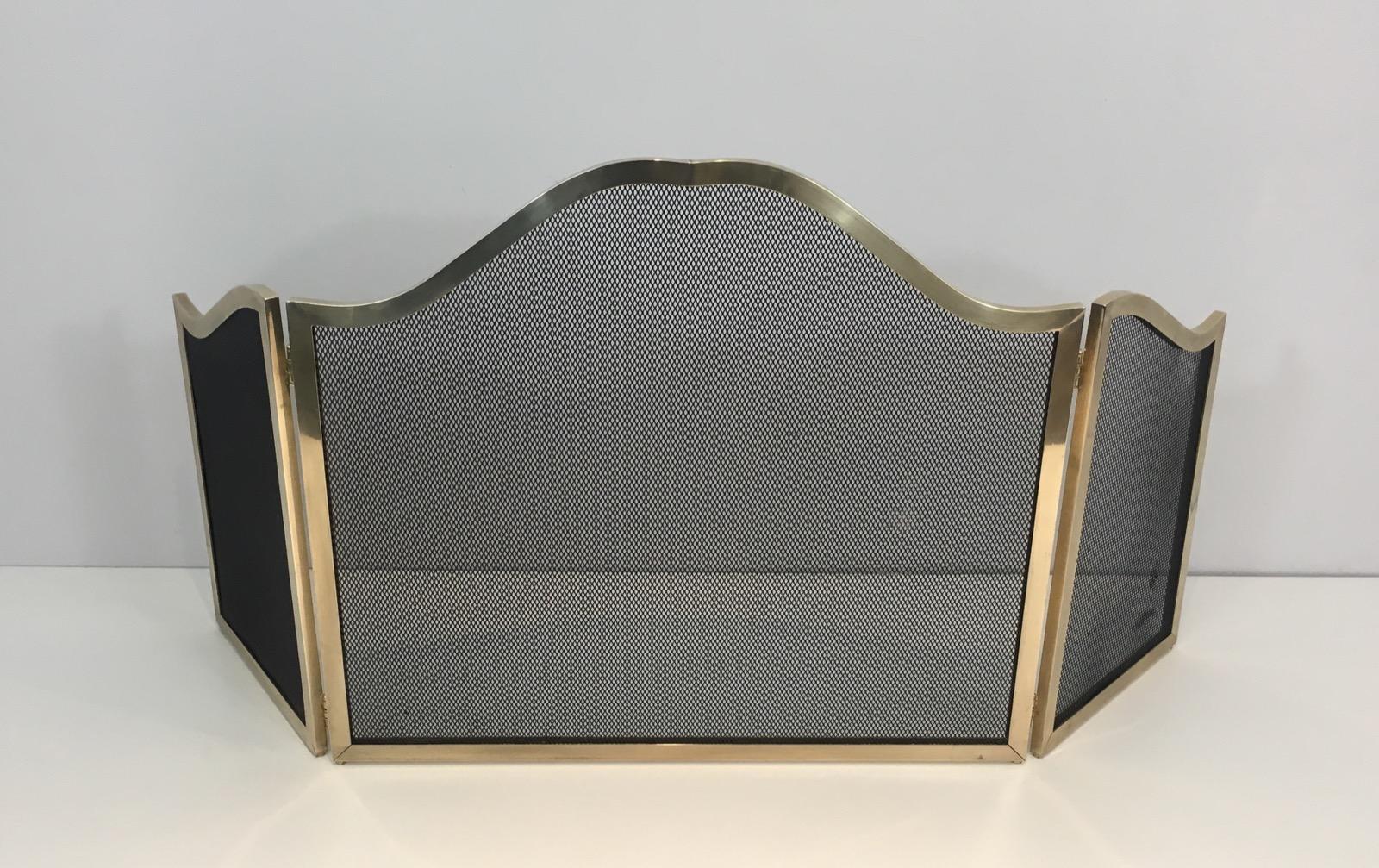 This fireplace screen is French, circa 1970. It is made of brass with metal grilling. Very elegant shape and beautiful quality.