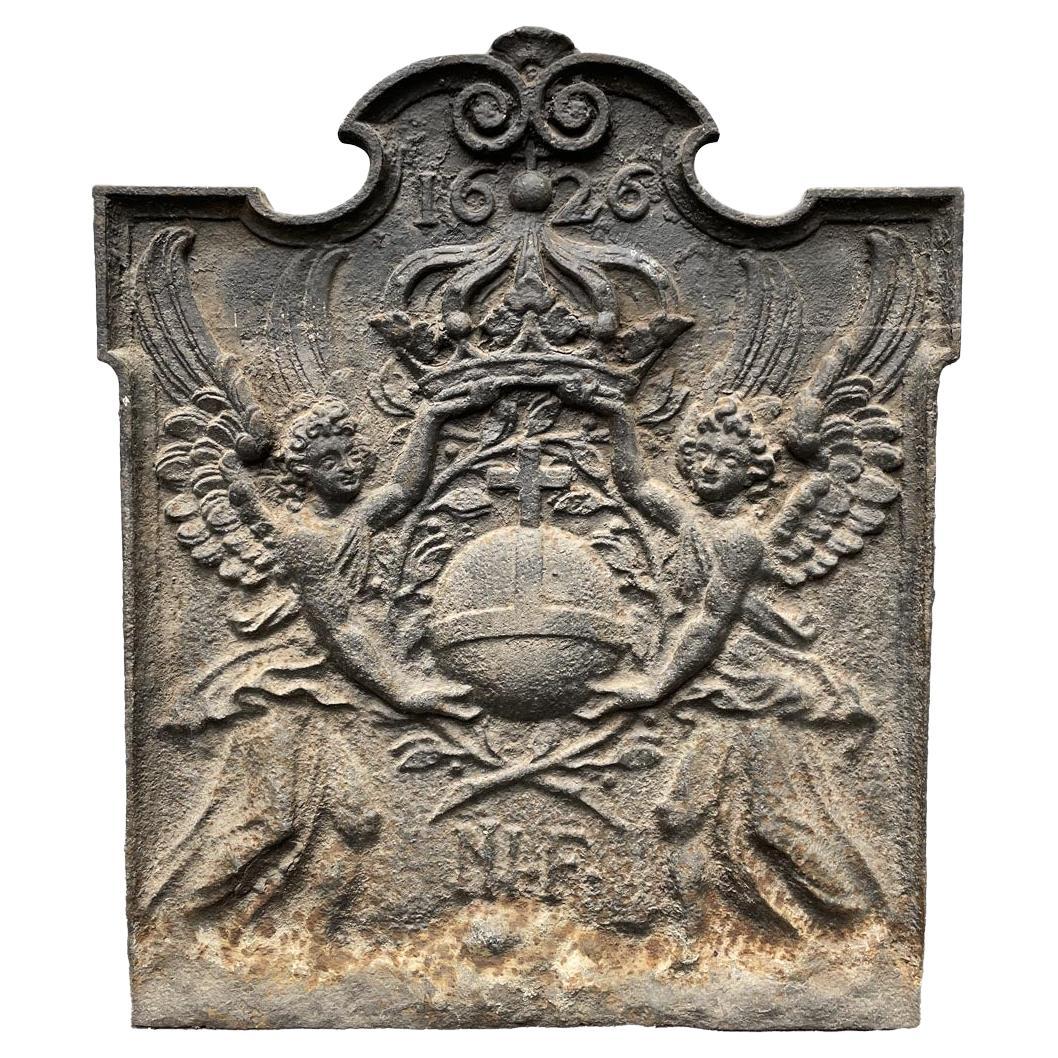 Plaque de cheminée datée de 1626 représentant un orbe Crucifereux encadré par deux Anges
