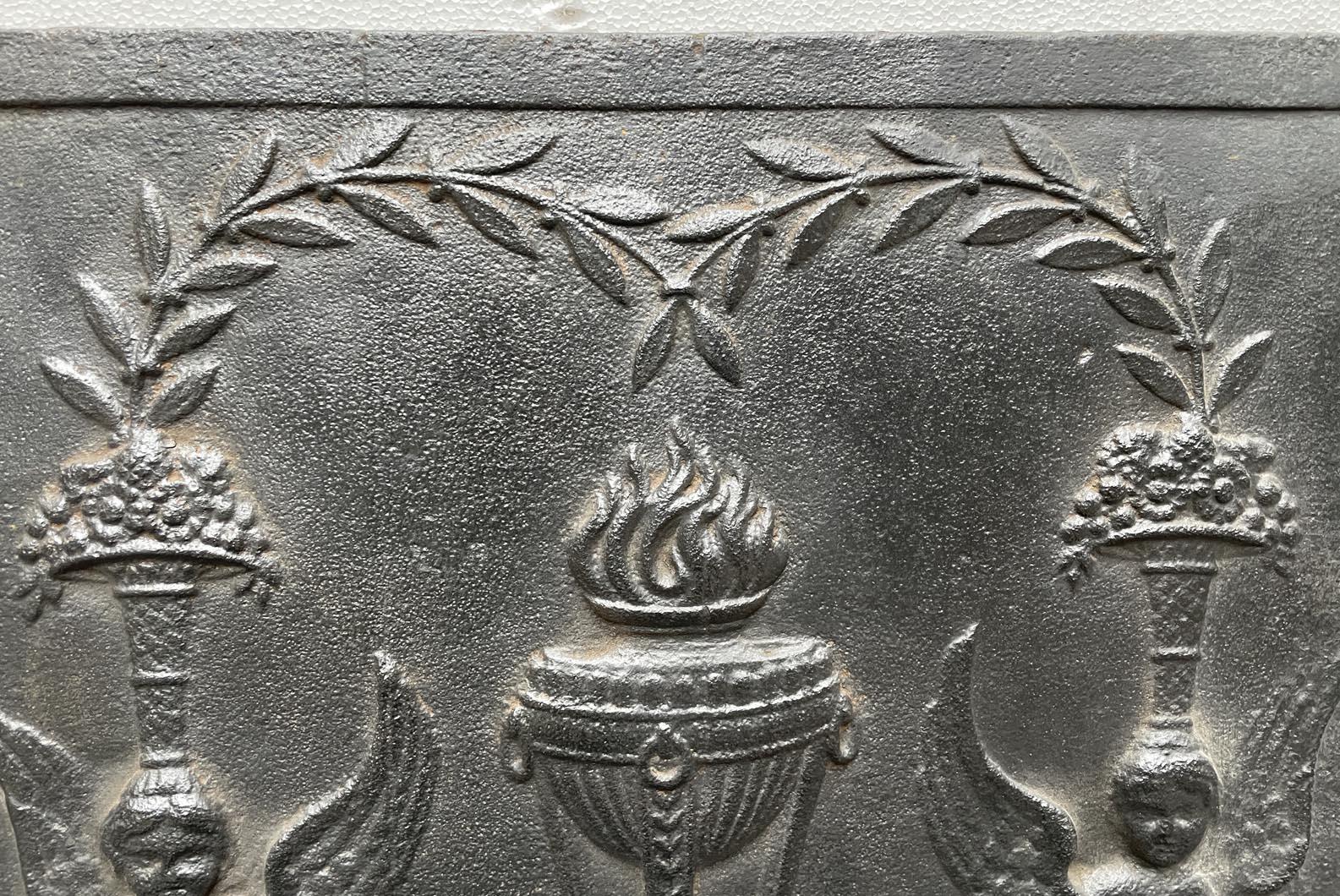 Fireback from the end of the 18th century with a vase of flames framed by sphinges.