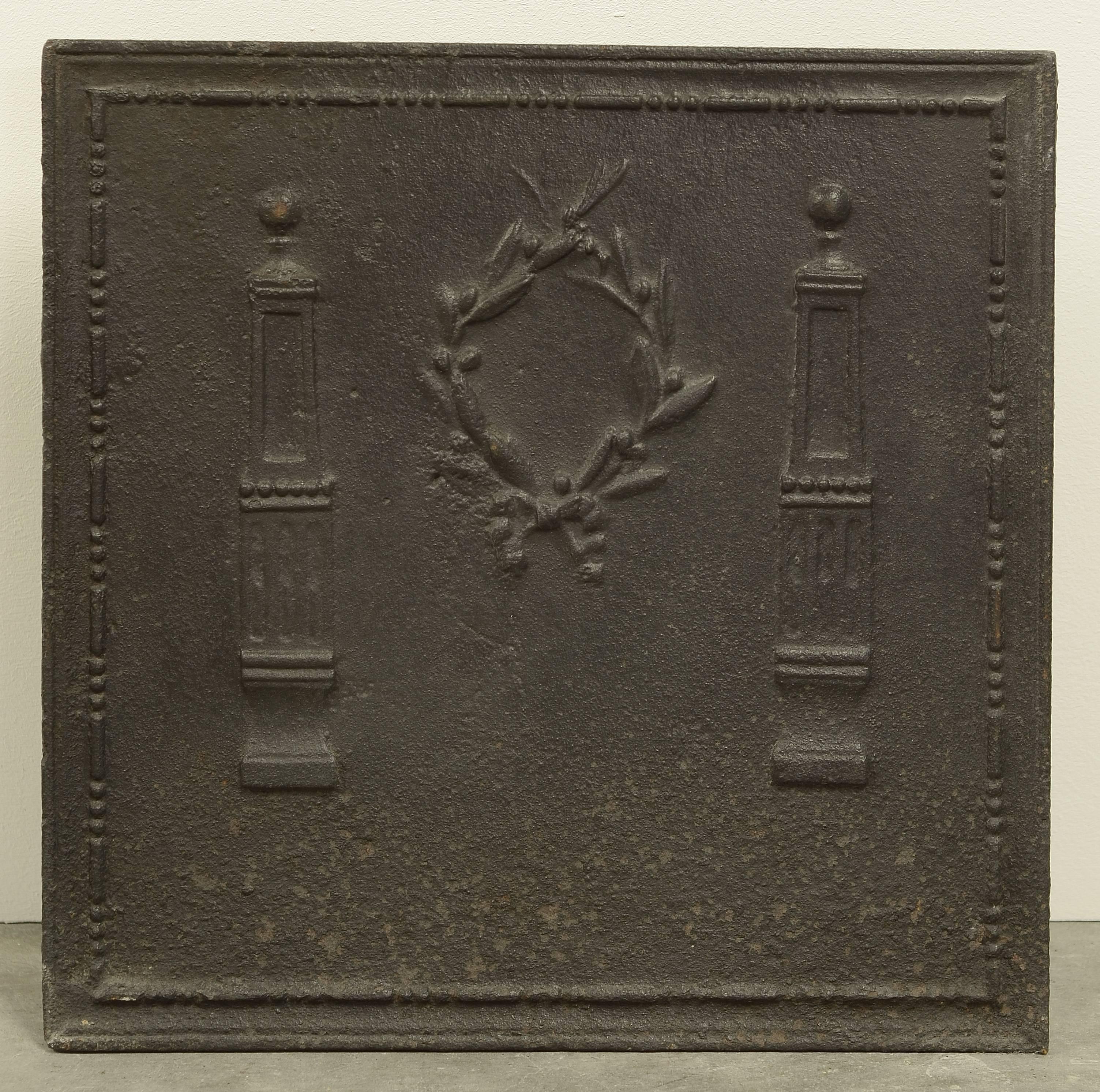 Small square antique fireback with Laurel Wreath between Pillars, 19th century.

Great usable dimensions.
Excellent condition, can be used in a fire or as backsplash.

Can be supplied with stand.