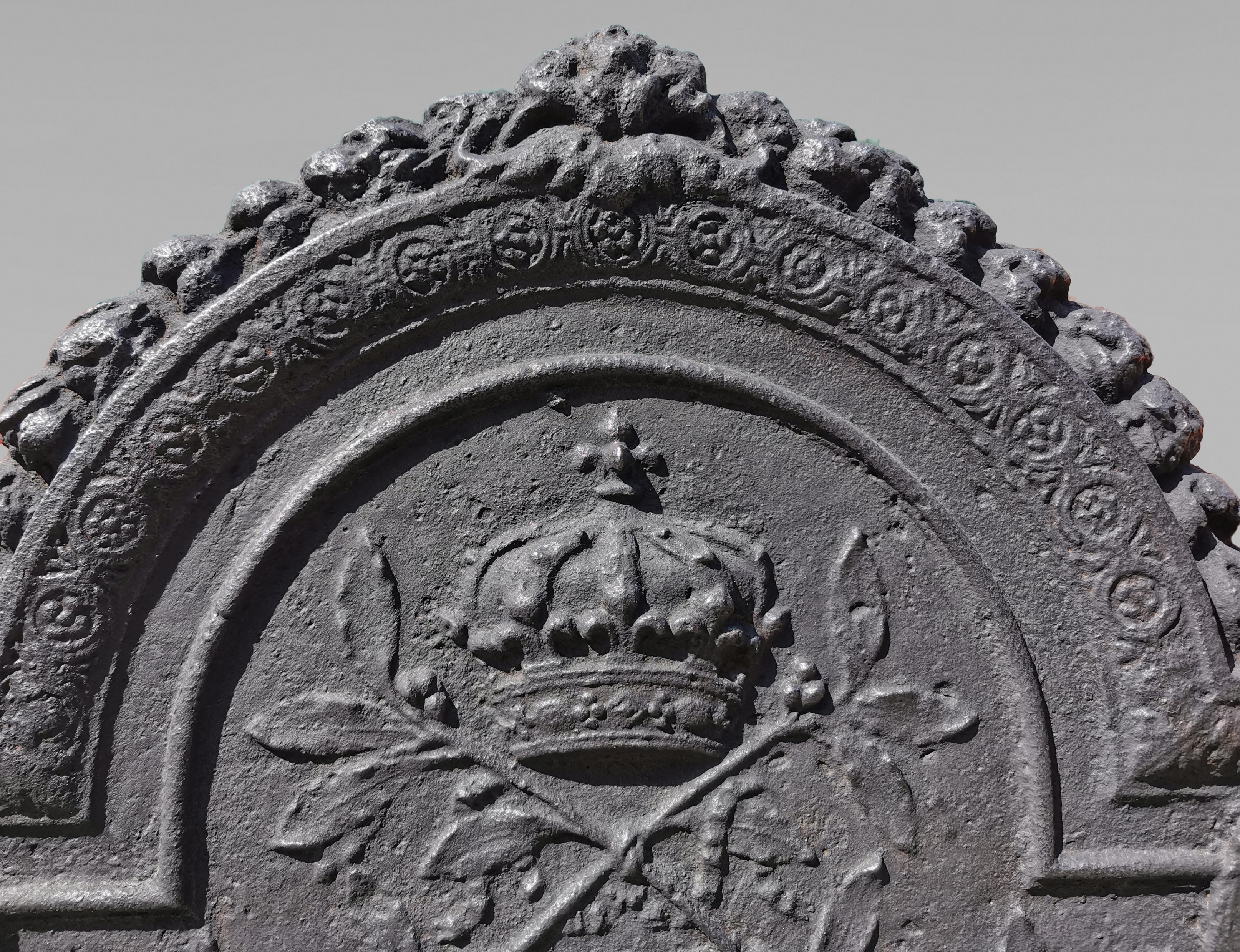 Dieser schöne gusseiserne Kamin aus der Zeit um 1700 ist mit einem seltenen und reichen Dekor verziert.
Seine Form ist charakteristisch für die Anfänge des 18. Jahrhunderts, die Spitze in einem Bogen eines Kreises Form wird von zwei Hähnen, deren