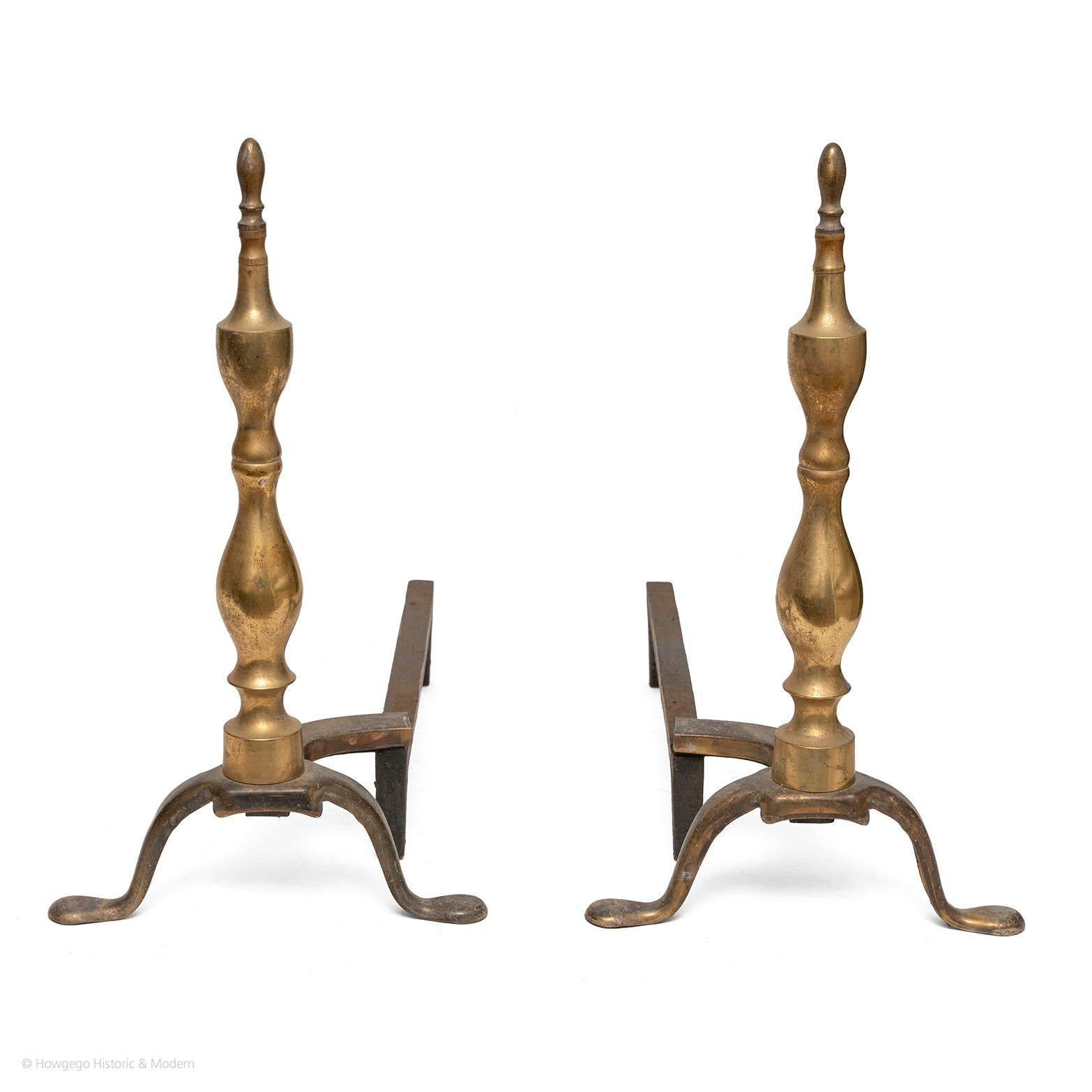 Elegant pair of brass and wrought iron firedogs with classic split baluster form inspired by Neoclassical design
The height creates a sleek elegance
The brass reflects the light from the fire into the interior
Soft patina, can be polished if