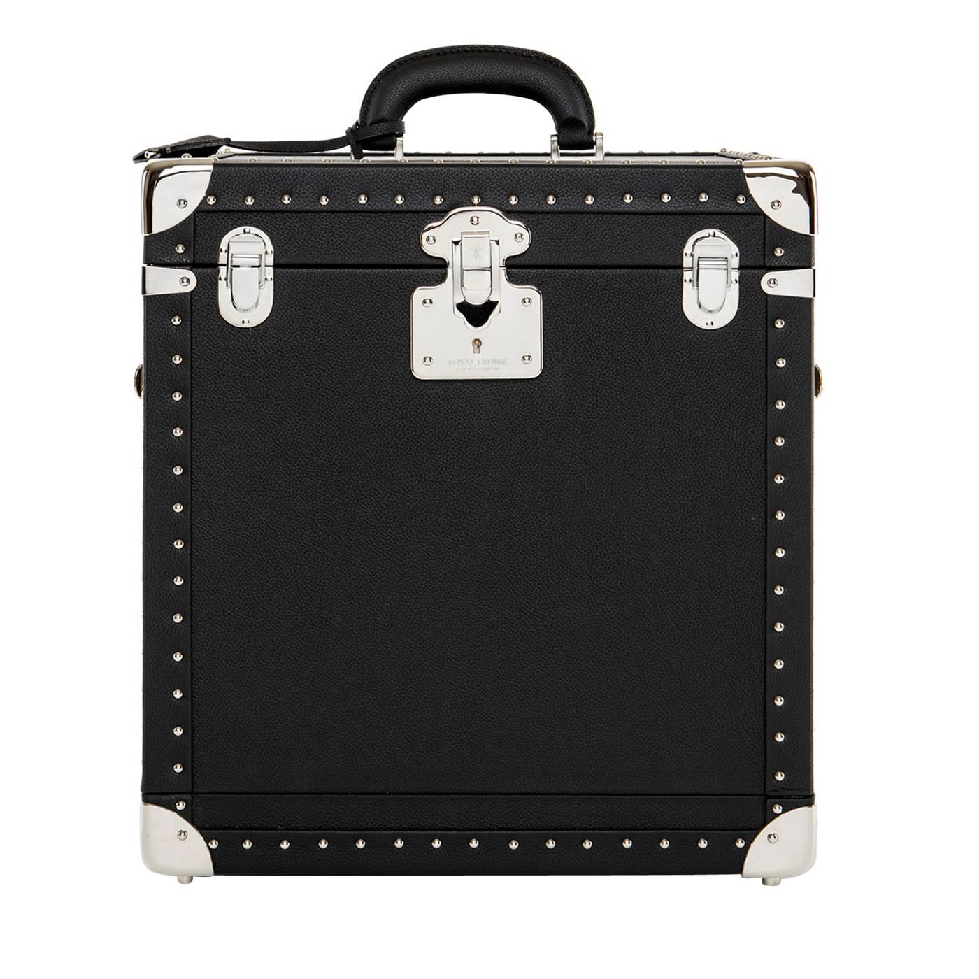 This refined beauty case created both for men and women features a leather exterior with handles in brass and decorated with handmade nails along its entire perimeter. The interior is lined in microfiber with a fixed mirror at the top and an