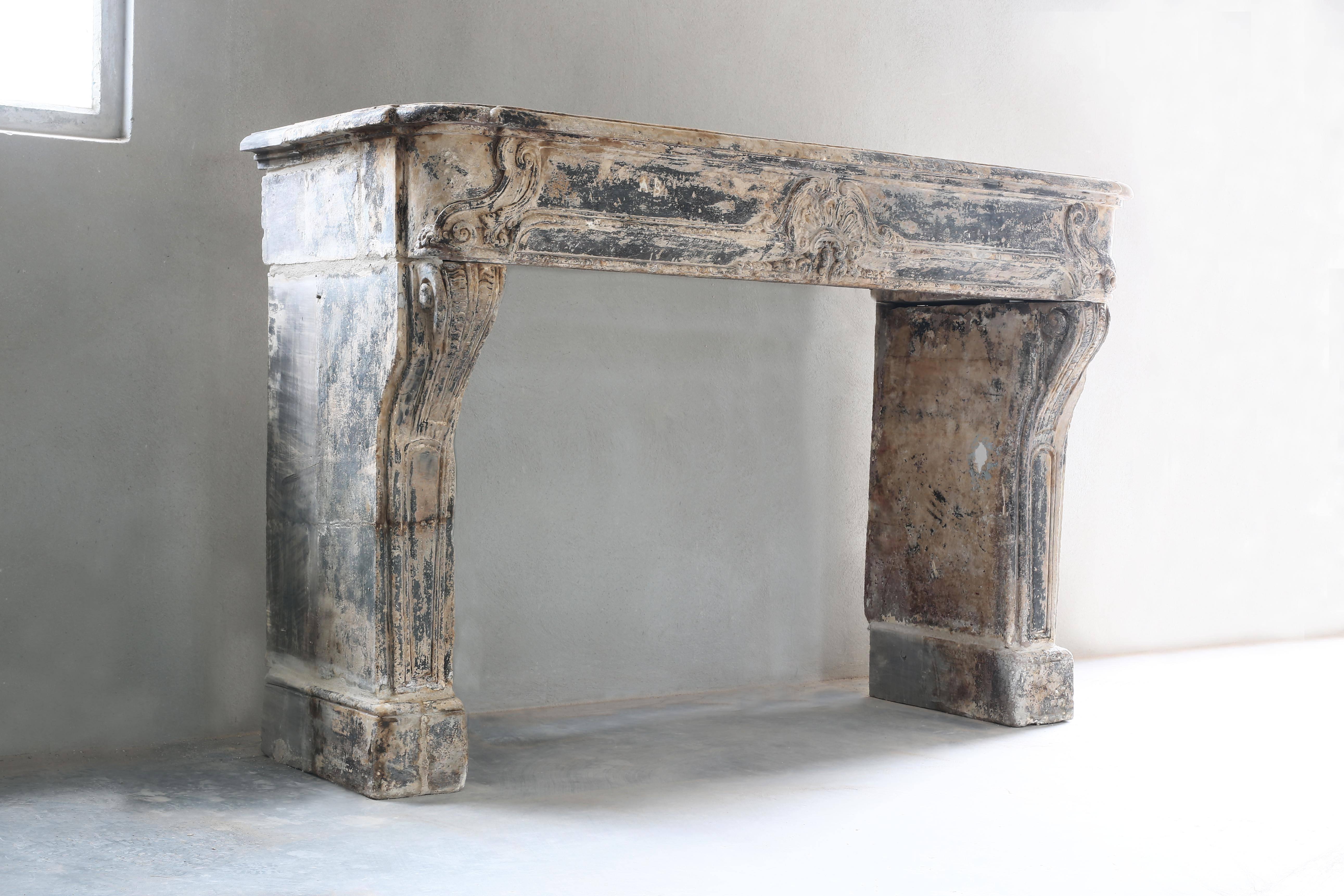Beautiful patinated antique fireplace from the 18th century in the style of Regénce. The chimney has a beautiful color and elegant shape. Other indications for the Regénce style are late Baroque and pre-Rococo. Characteristic of fireplaces from this