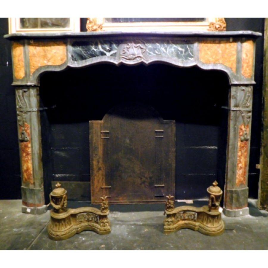Ancient antique fireplace mantel in inlaid and precious gray, black and yellow marble, richly hand carved by an artist of the time with a central shell, and inlaid decorations on the sides. It has a nice move and gives light and colorful elegance to
