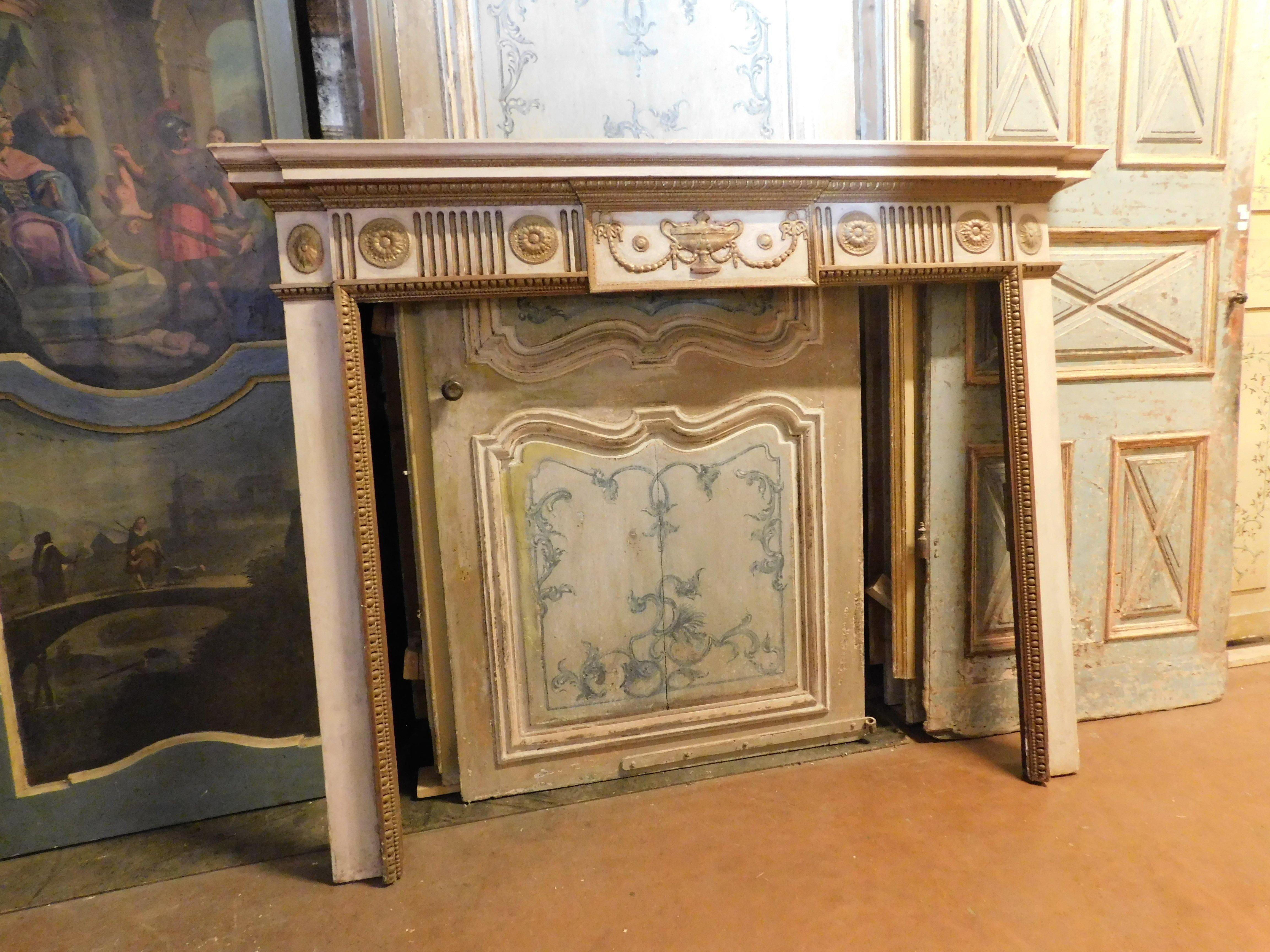 Antique fireplace mantle in poplar wood, hand-carved with period decorations and festoons, central cup, lacquered on a white background with gold details, built and original from the late 18th century, from France.
External maximum size cm w 190 x