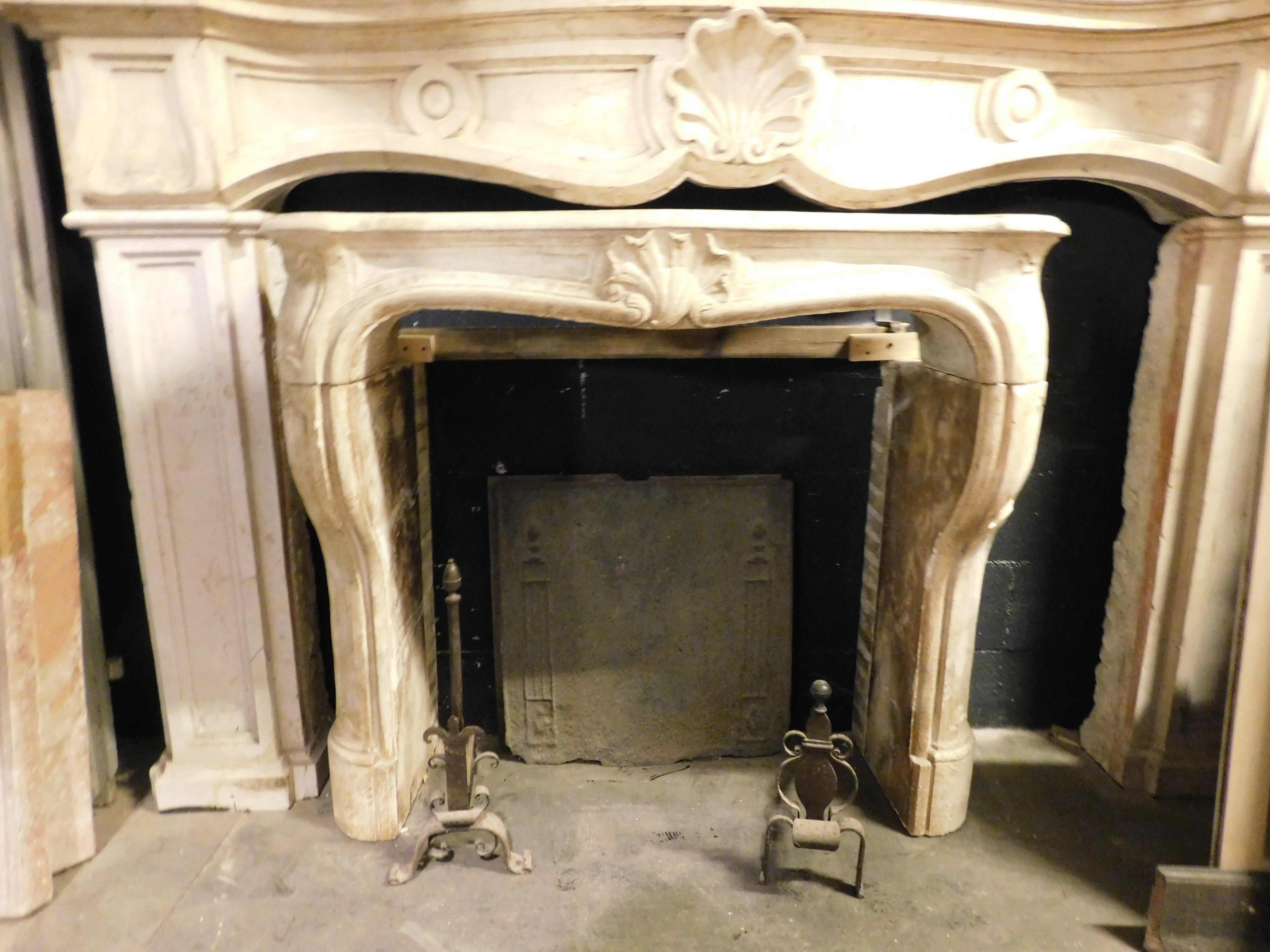 Ancienne cheminée en pierre de Bourgogne sculptée à la main avec coquille centrale et pieds ondulés, la façade est également ondulée, ce qui la rend très fascinante et de forme historique ancienne typique, construite en France avec des pierres