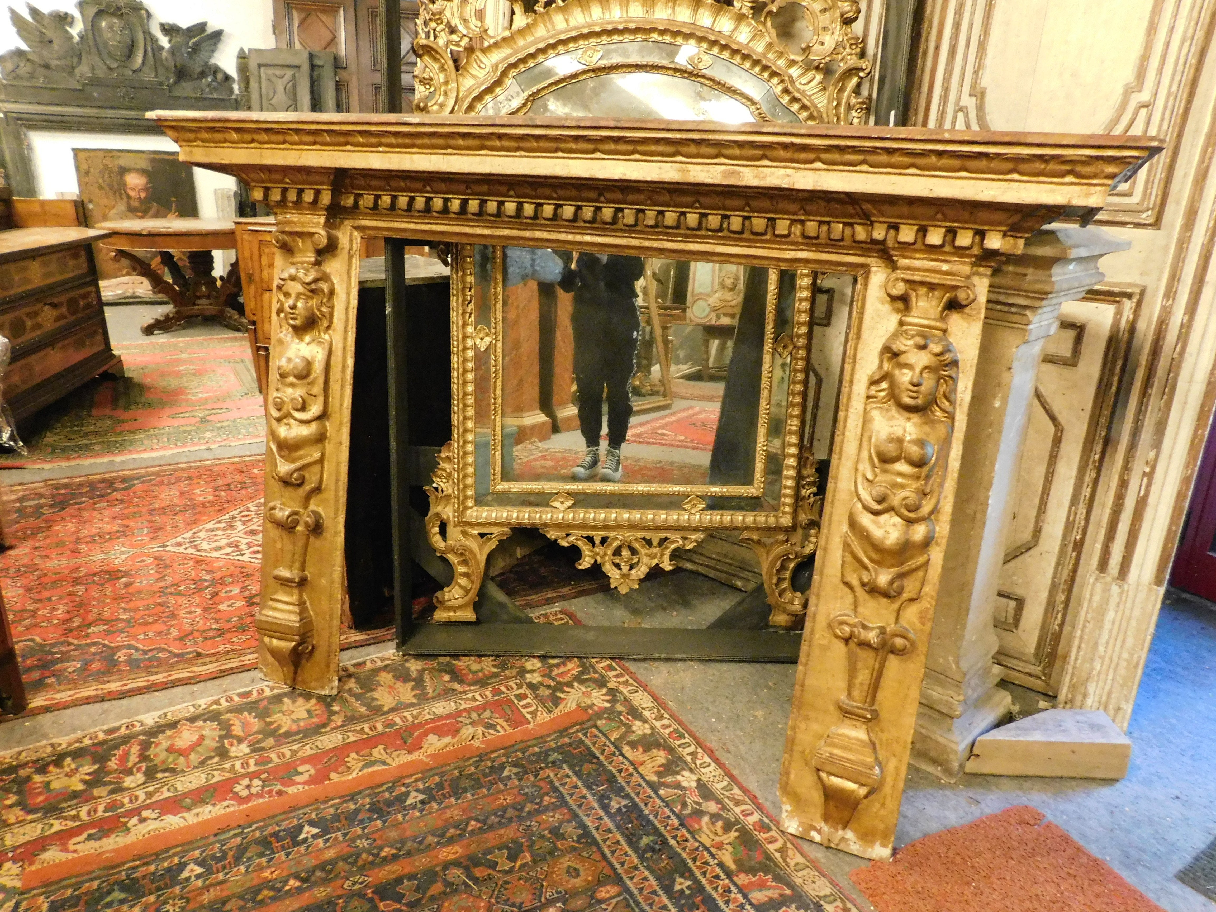 Cheminée ancienne, en bois laqué doré et richement sculpté, pieds sculptés avec une paire de cariatides originales et une étagère à baldaquin, construite au XVIIIe siècle en Italie, avait une fonction décorative pour le coin du feu.
Il peut