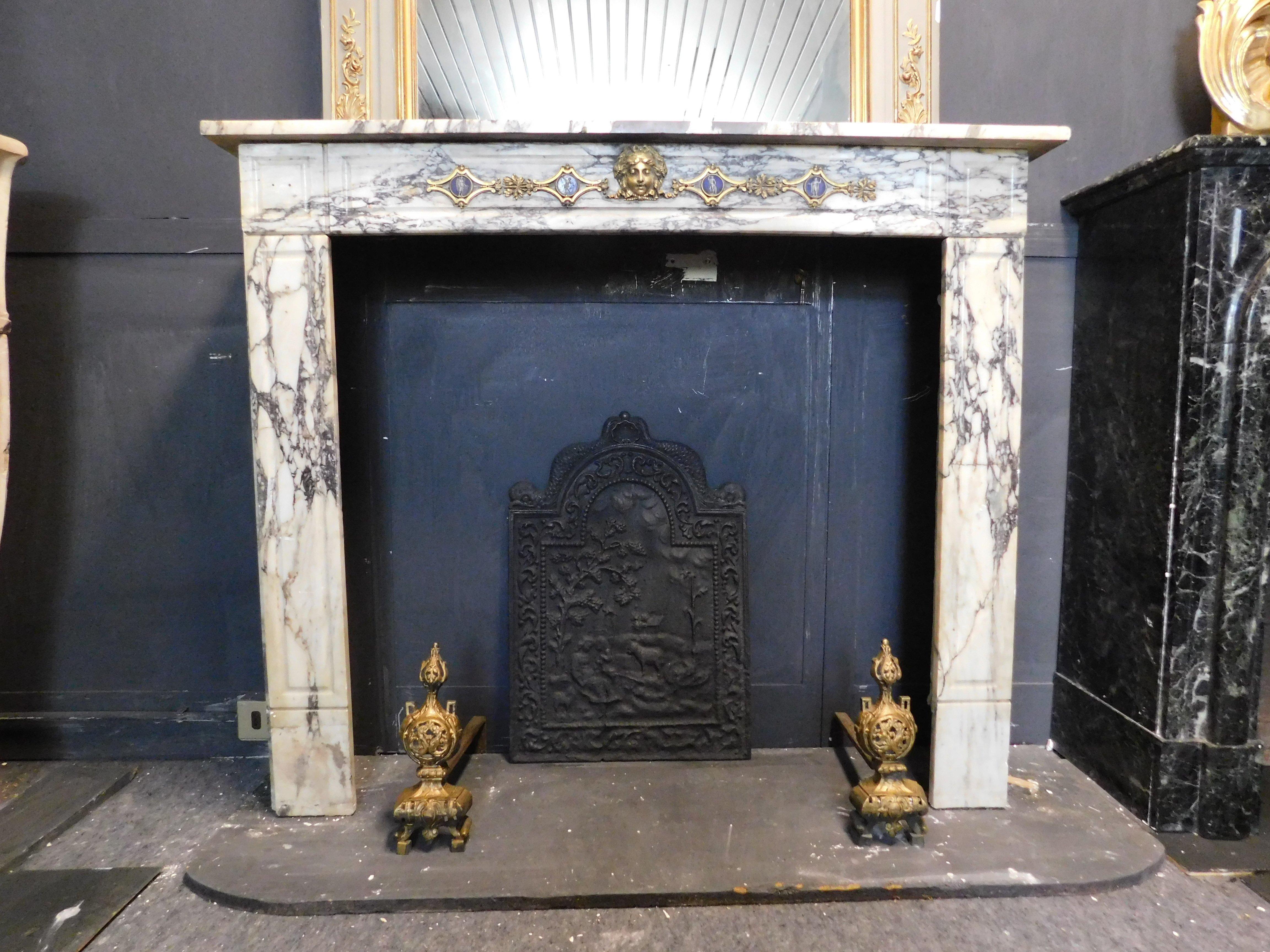 Antique fireplace in gray/purple veined white marble, embellished with friezes and brass sculptures applied over the marble, built in the early 1900s for a palace in Italy, ideal for apartments or small elegant houses, given the small size, refined