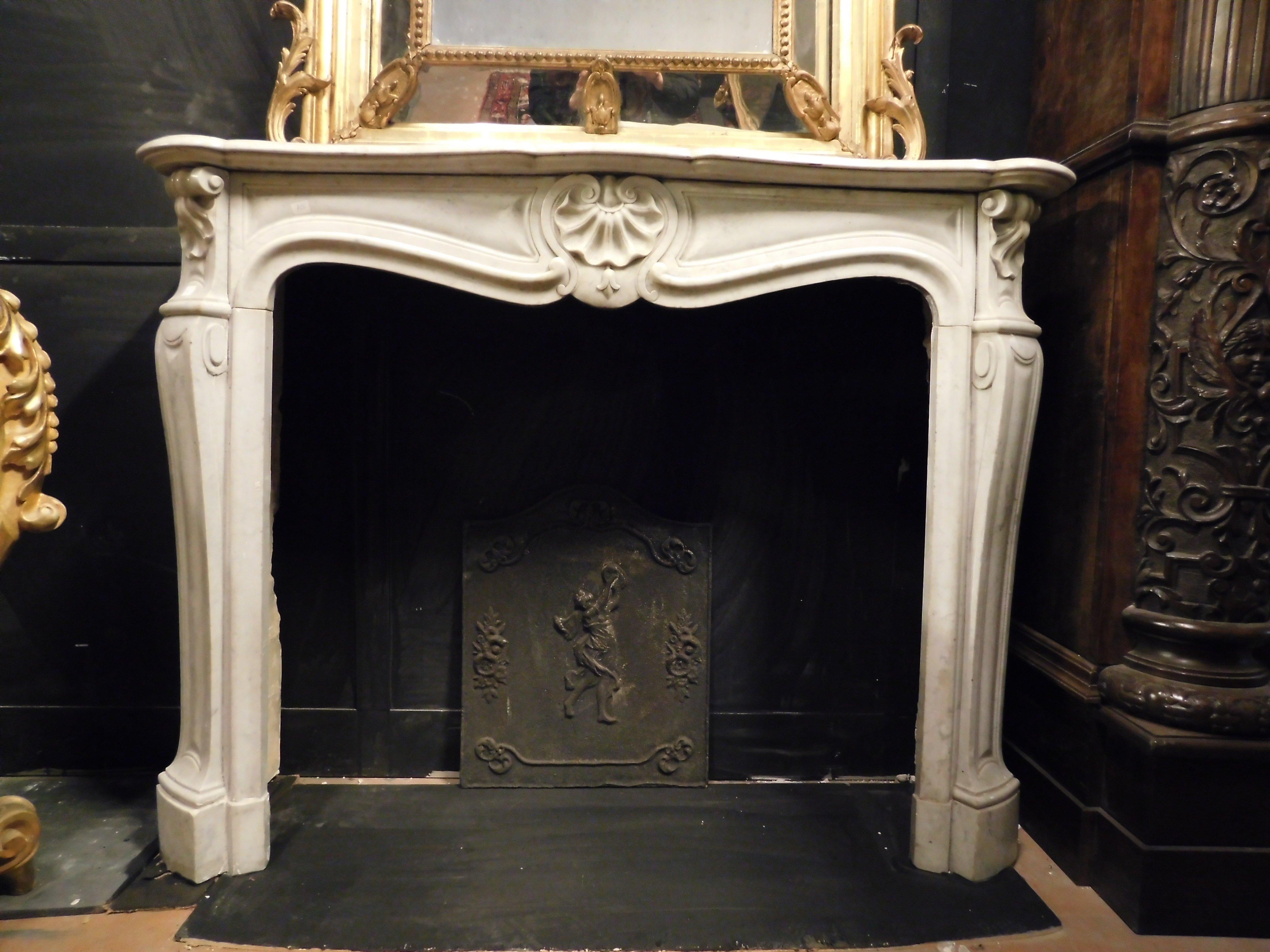 Fascinating antique fireplace mantle in white Carrara marble, carved with a central shell.
Known throughout the world for its uniform and homogeneous pure white color with gray veins, White Carrara marble is also distinguished by some important