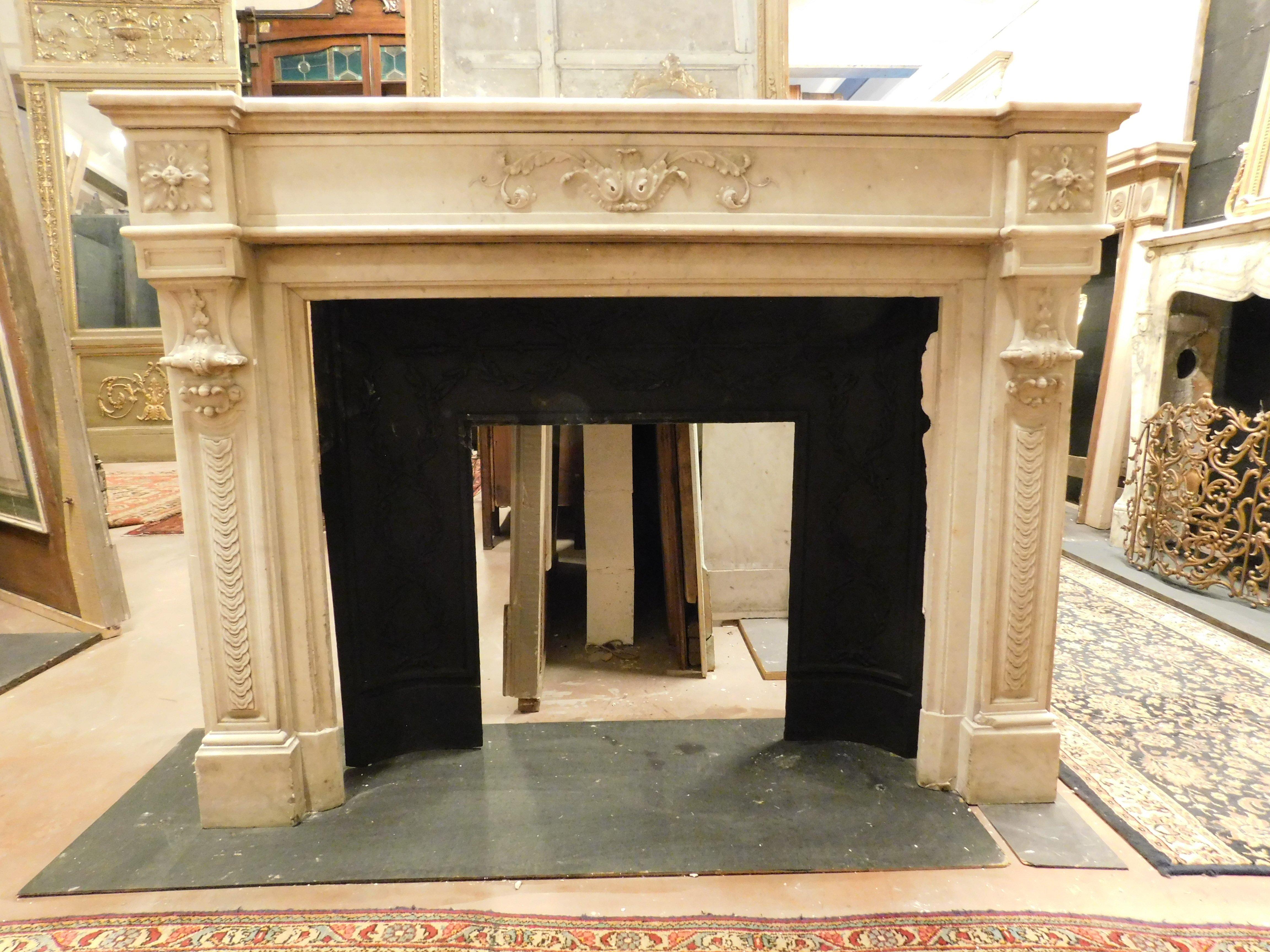 Ancient fireplace mantle in white Carrara marble, richly hand-sculpted with flowers on the pediment and legs enriched by hand sculptures, built in France in the 19th century.
The fireplace is sold WITHOUT the black part which is for display only,