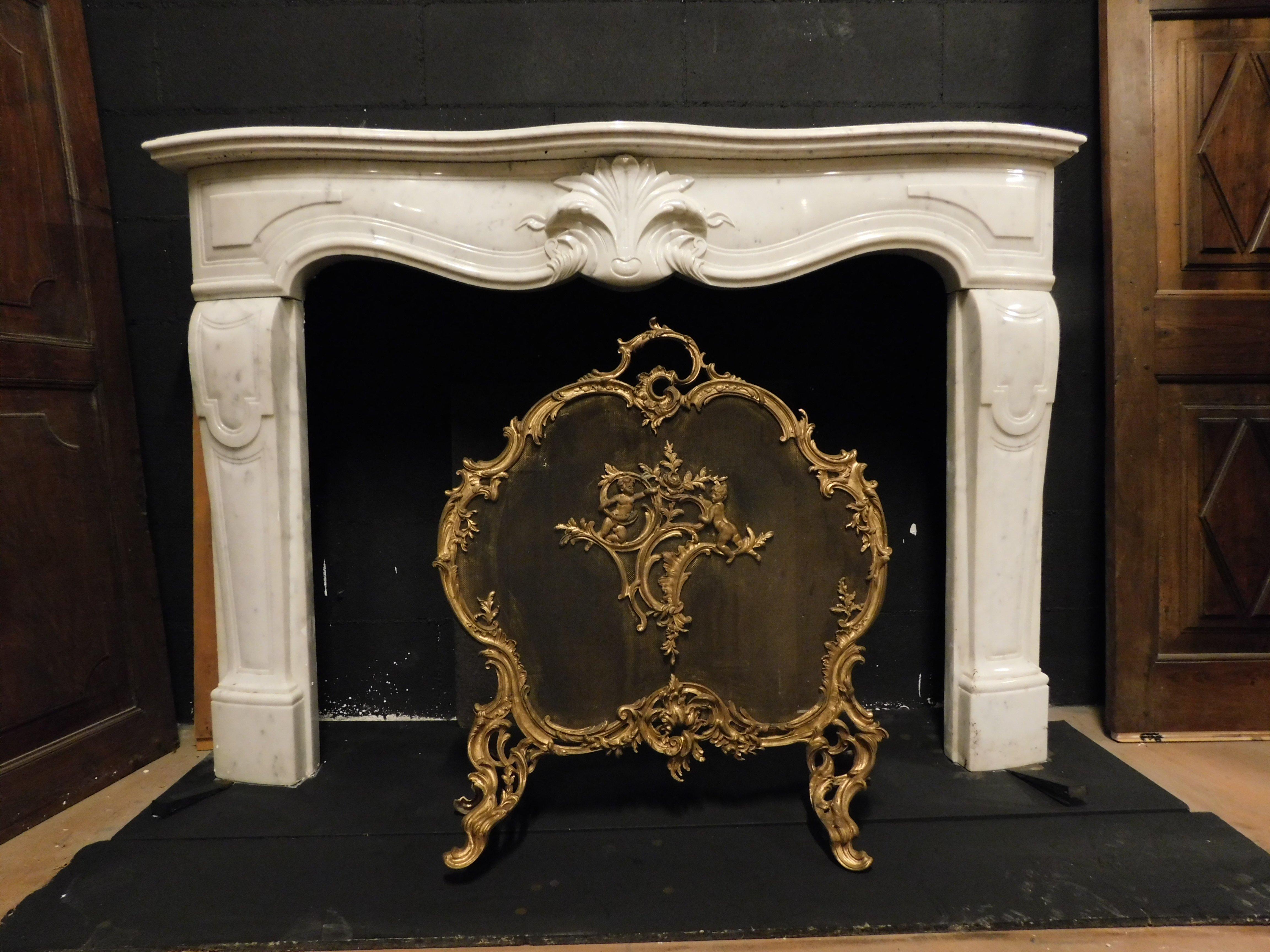 Antique fireplace mantle, richly carved in precious white marble with central leaf and wavy legs, from France, 19th century, very elegant and refined, to give a touch of classic elegance and chic taste to your prestigious interior, maximum
