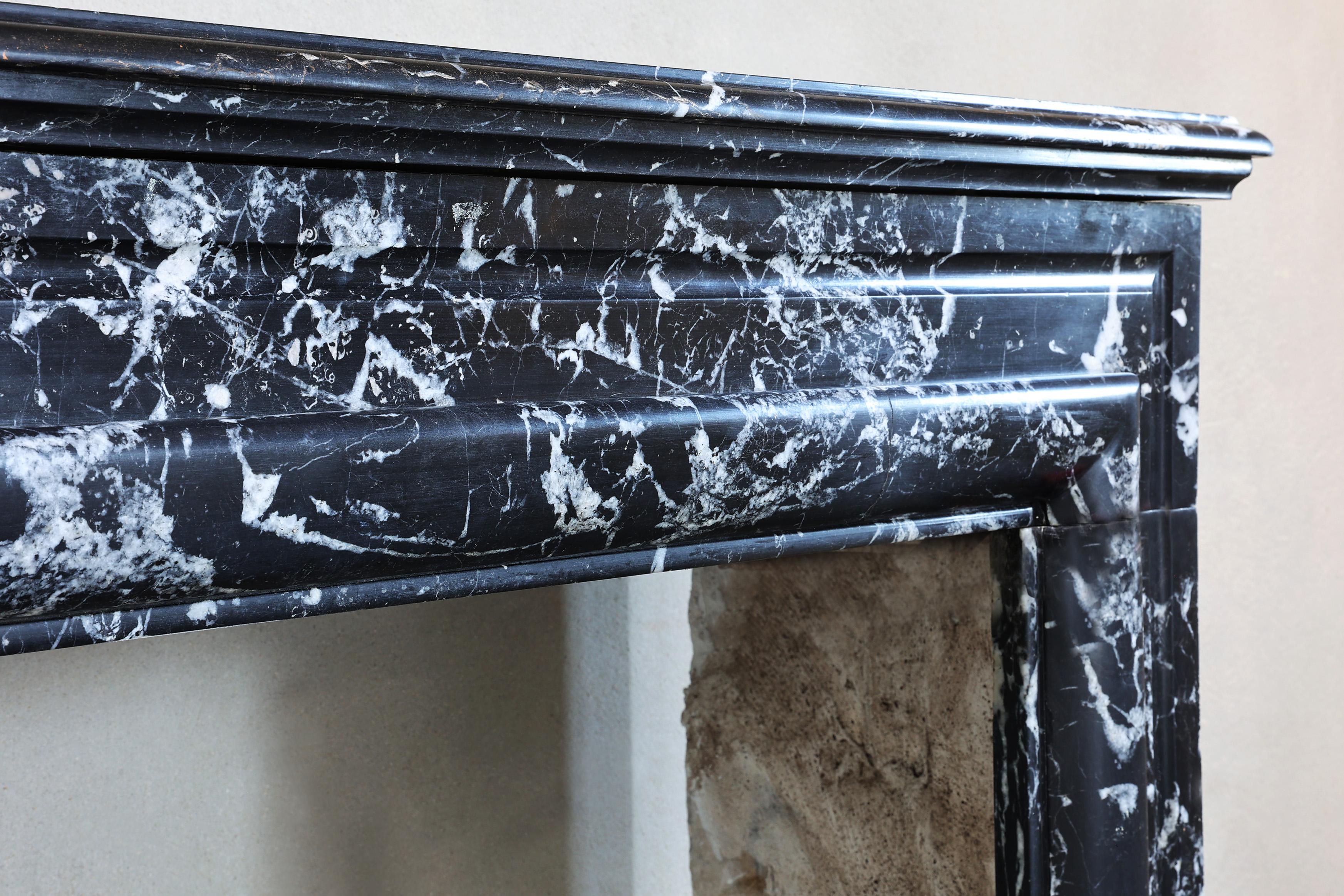This antique Marquina marble fireplace in the style of Louis XVI comes from the 19th century and is a beautiful stylish piece of furniture for a classic or modern interior. This black and white marble is often used in classic styles that were