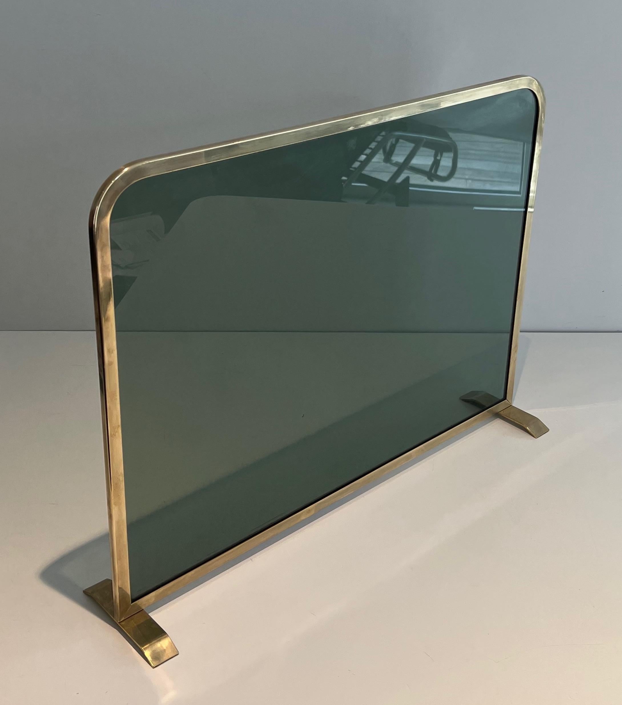 Mid-Century Modern Fireplace Screen Made of a Greenish Glass Panel Surrounded by a Brass Frame For Sale