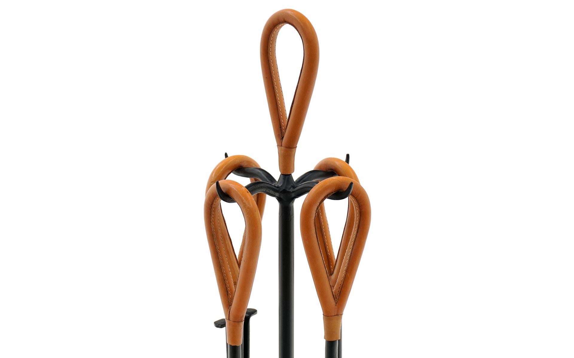 Fireplace tool set in solid iron and cognac leather wrapped handles in the style of Jacques Adnet. Very high quality construction and apparently used very little. The handles show no signs of wear and the iron portions show very little. These look