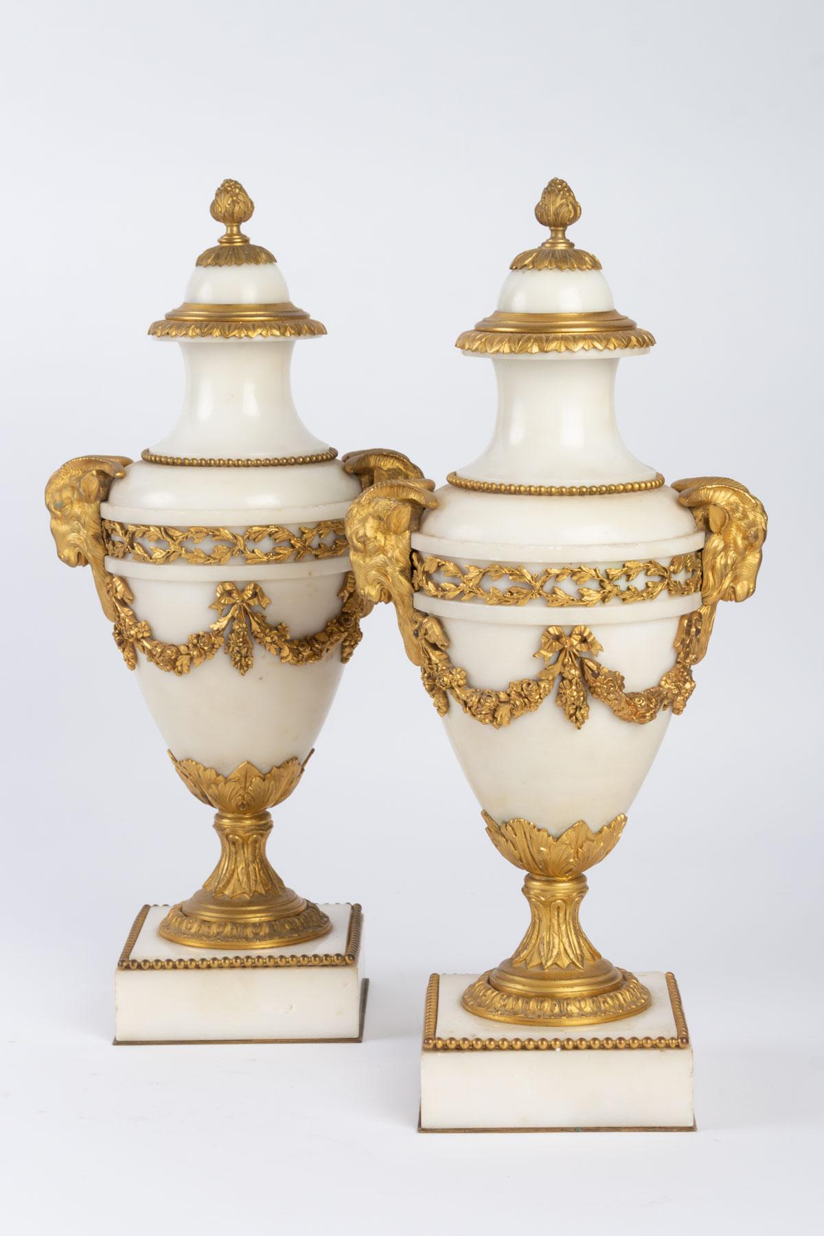 Fireplace trim in the form of cassolettes. Very pure white marble and finely chiseled gilt bronze with garland of flowers and ram's heads Louis XVI style, first half of the 19th century.

Measures: H 38 cm, W 17 cm, D 10.5 cm.