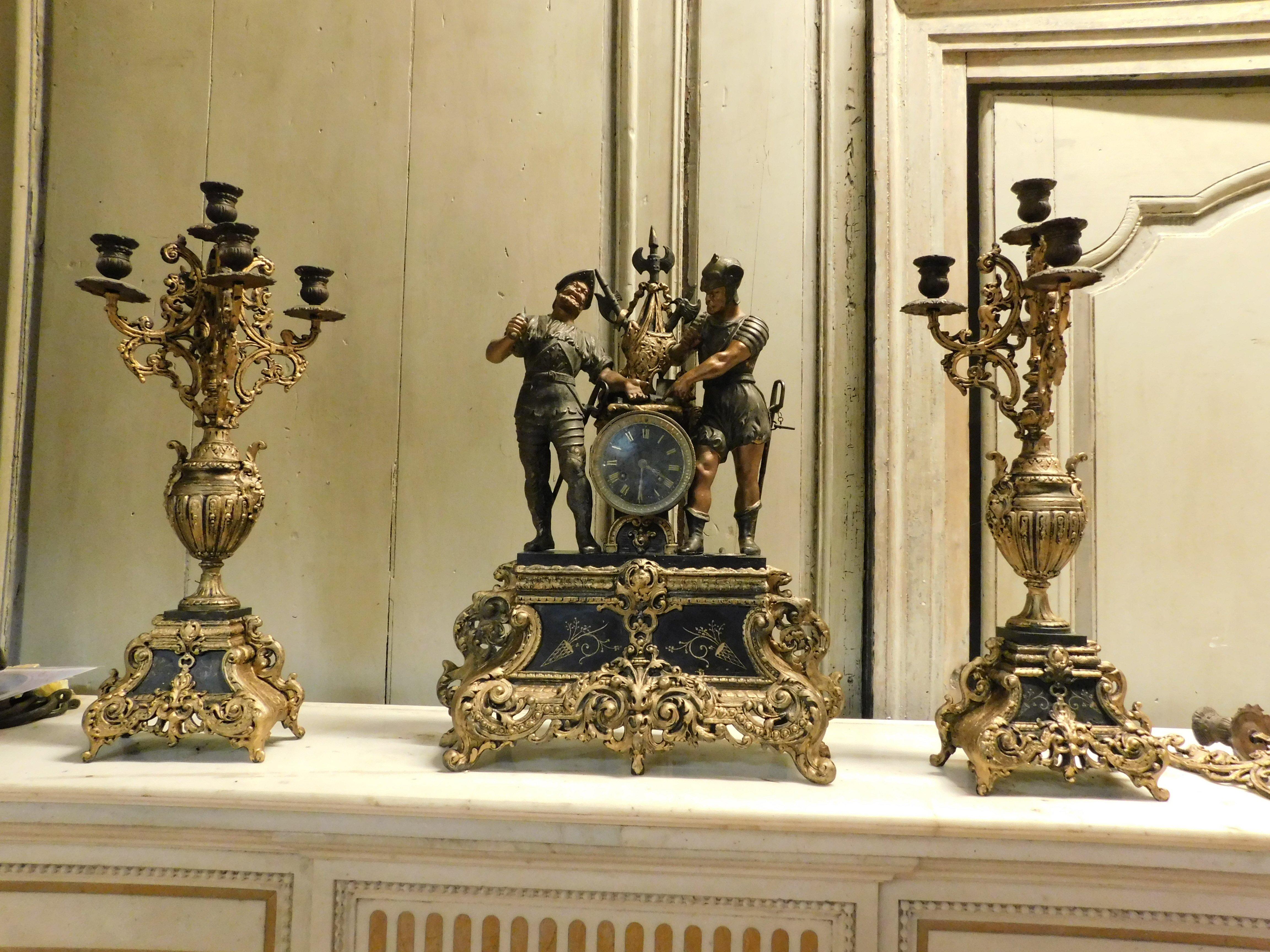 Ancient triptych over fireplace in richly sculpted, lacquered and gilded bronze, set consisting of 1 clock and 2 candlesticks, made by master craftsman in Italy in the second half of the 19th century, the clock measures cm w 43 x h 57 x d 15, the