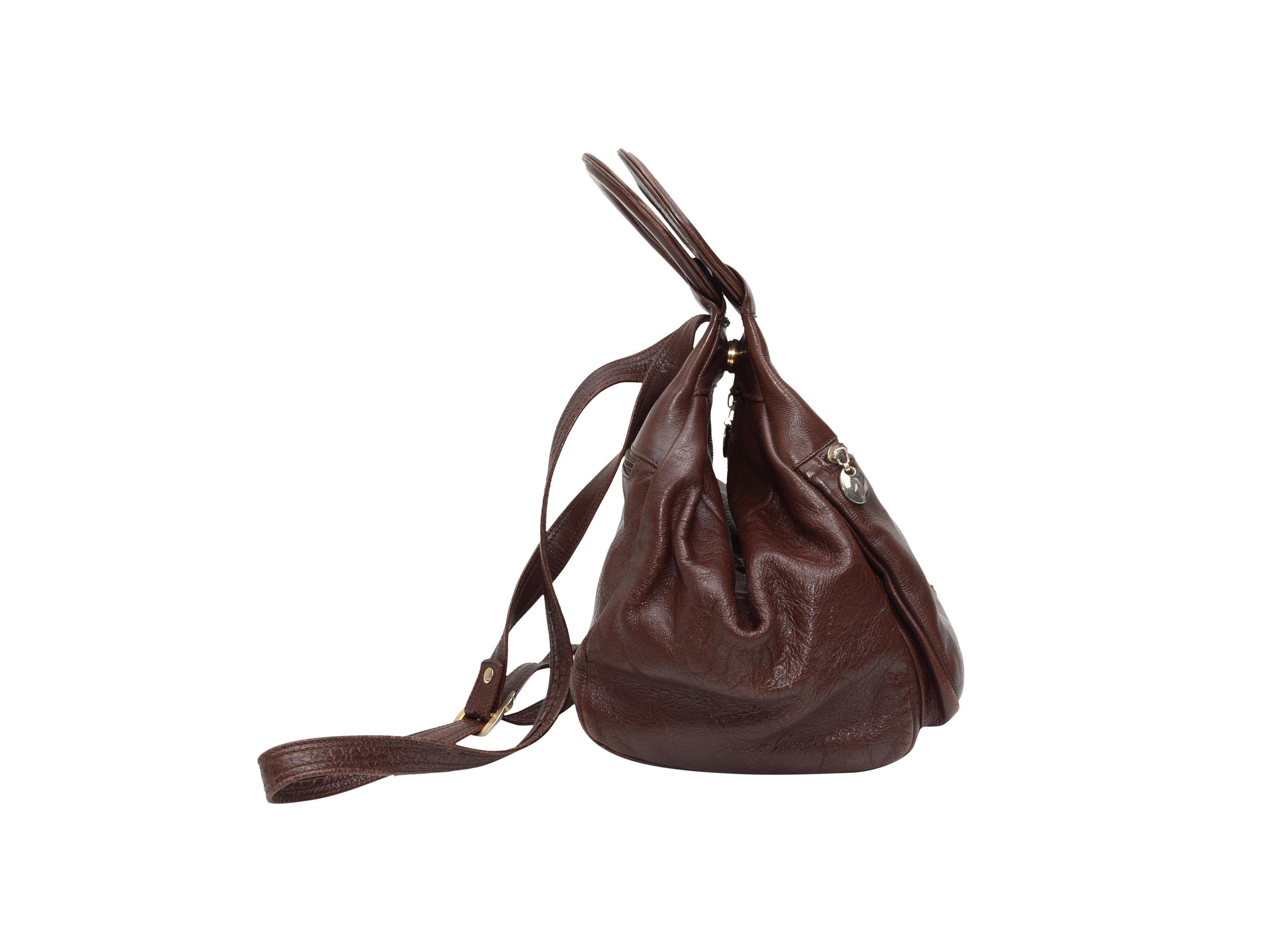 Product details: Vintage brown leather convertible handbag backpack by Firina. Exterior zip pockets at front and back. Zip closure at top. 11