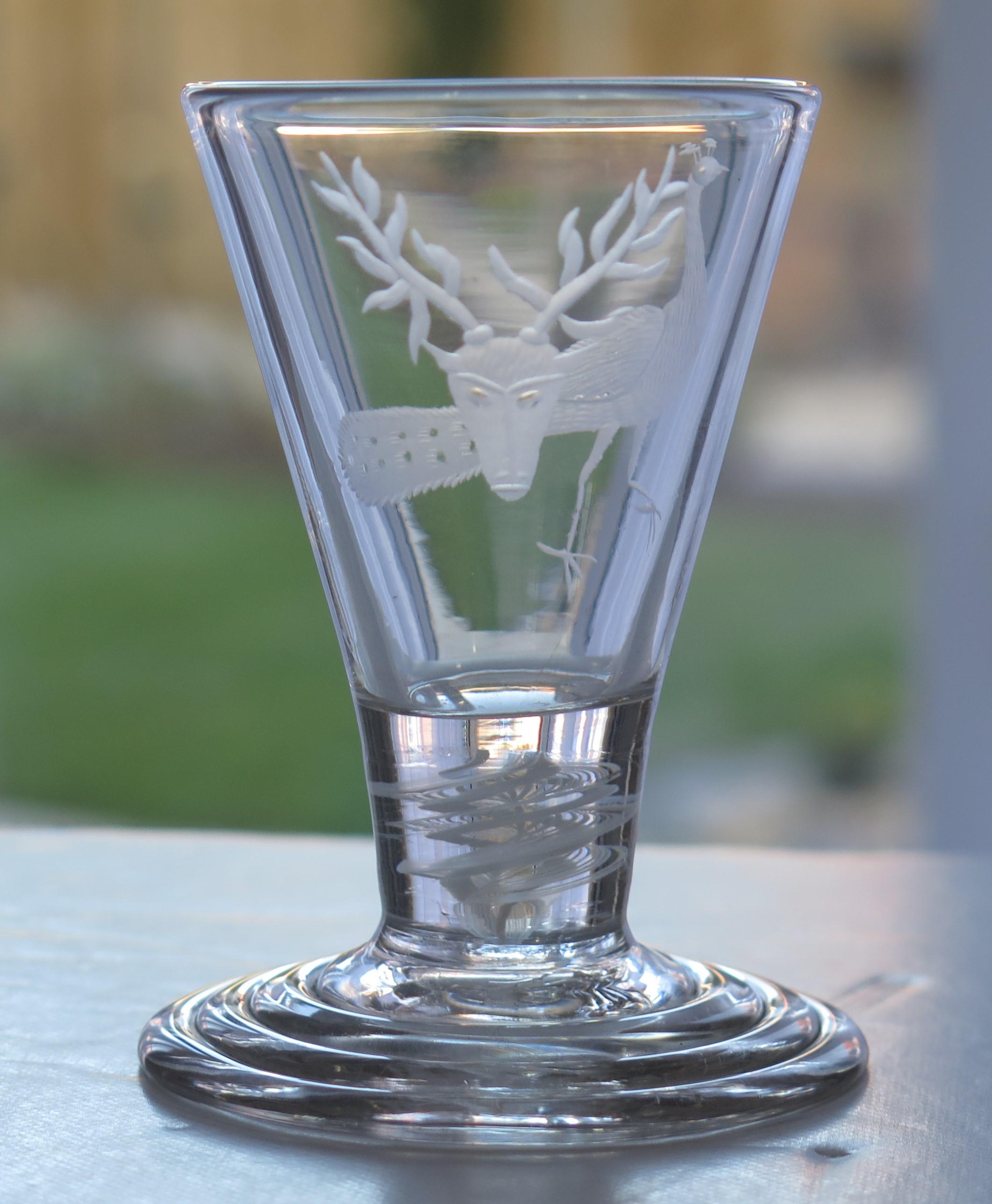 This is a fine, English, hand blown drinking glass, called a Firing Glass, made from lead glass in the 18th century, circa 1765.

Short, heavy, thick stemmed glasses like this with a thick foot and short stem are known as firing glasses, as they
