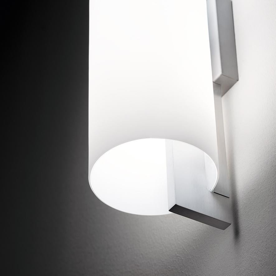 Please note that VAT is not included in the price.

Lighting system composed of pendant and wall version, realized with the combination of the smoothness of a hand-blown, satin glass and the stiffness of the aluminium bars. The two bars host 2 10W