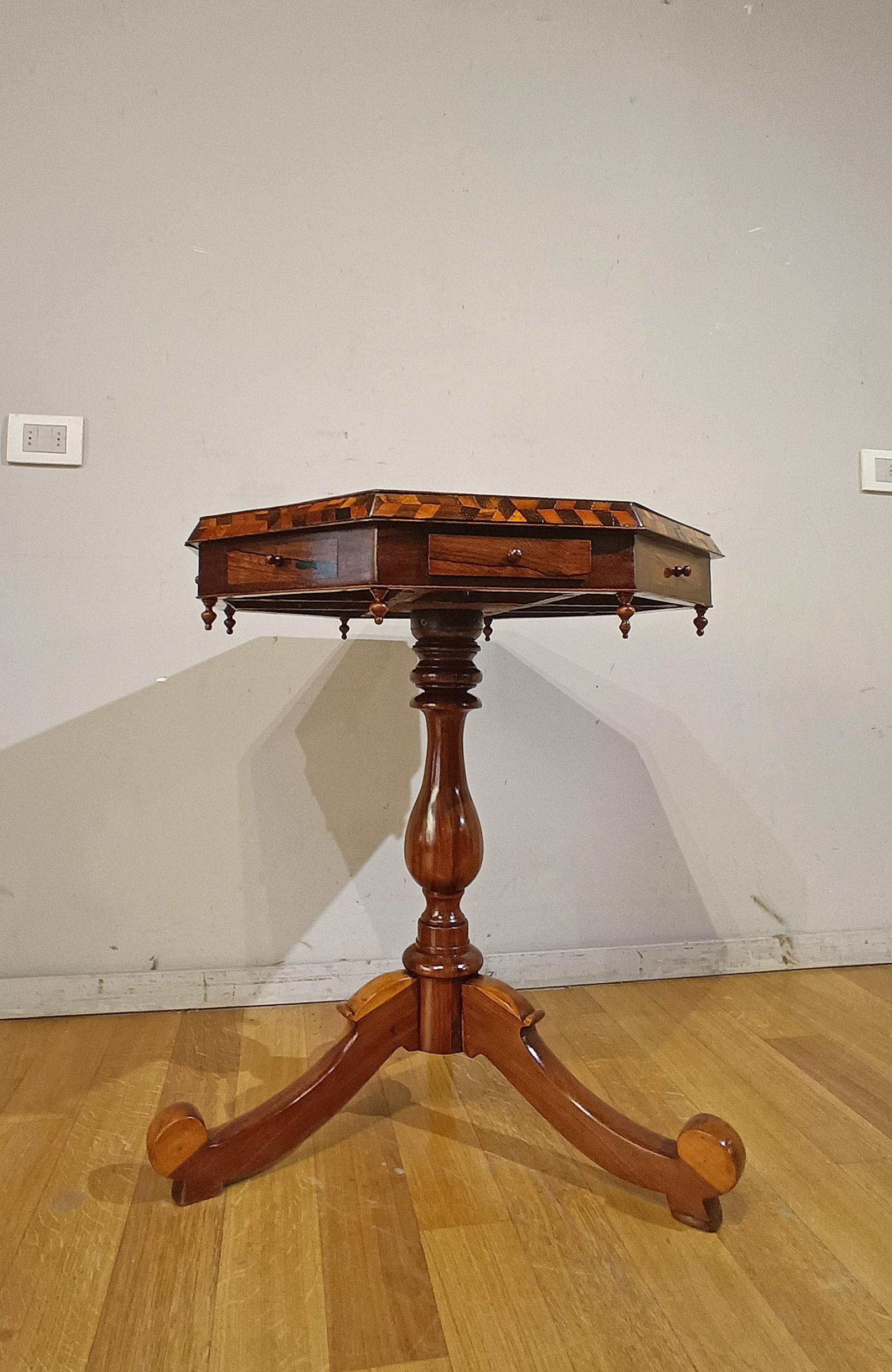 Elegant coffee table in solid walnut, embellished with parts finely inlaid with various fruit woods. The octagonal top is decorated with geometric and heart-shaped inlay designs, typical of the artistic tradition of Venetian inlay. There are four
