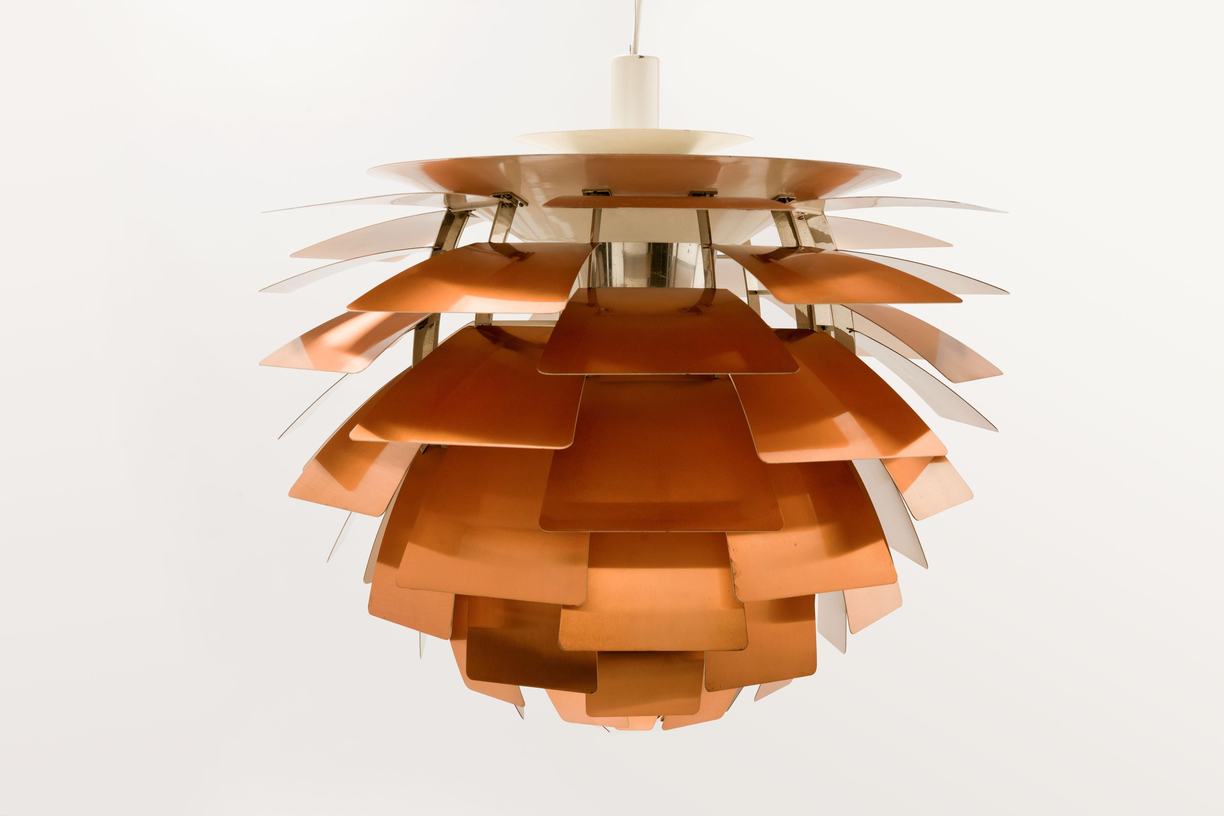 Rare first production series Artichoke, executed from a stunning aged golden copper, pendant by Poul Henningsen with production period related steel handles (2) on top rim. 
Originally designed in 1958 for a restaurant in Copenhagen called the