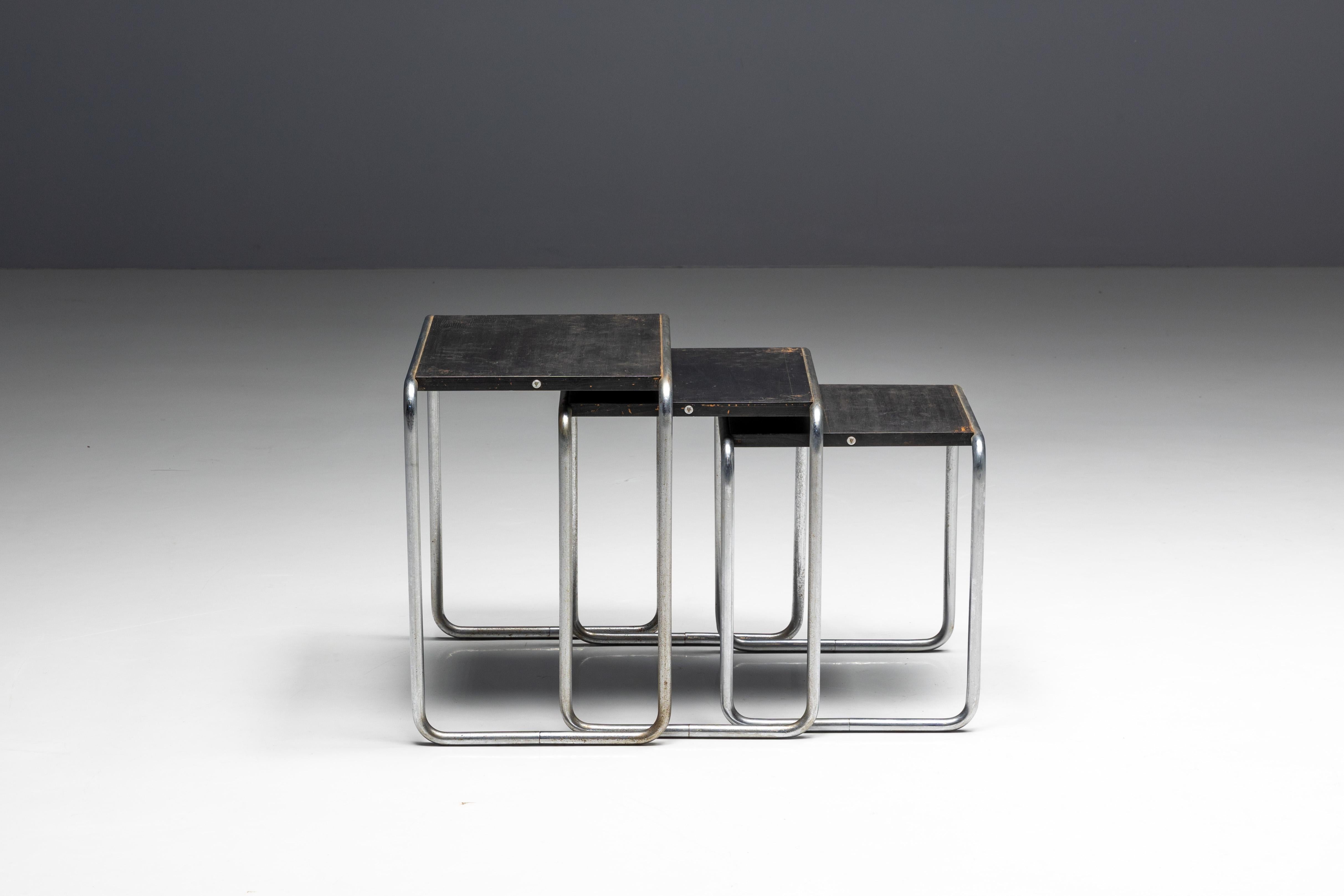 Mesas nido B9 de Marcel Breuer, un sello distintivo del diseño Bauhaus producido por Thonet. Fabricadas con acero tubular cromado y elegantes paneles de madera, estas mesas ejemplifican el innovador uso que Breuer hizo de los materiales y su visión