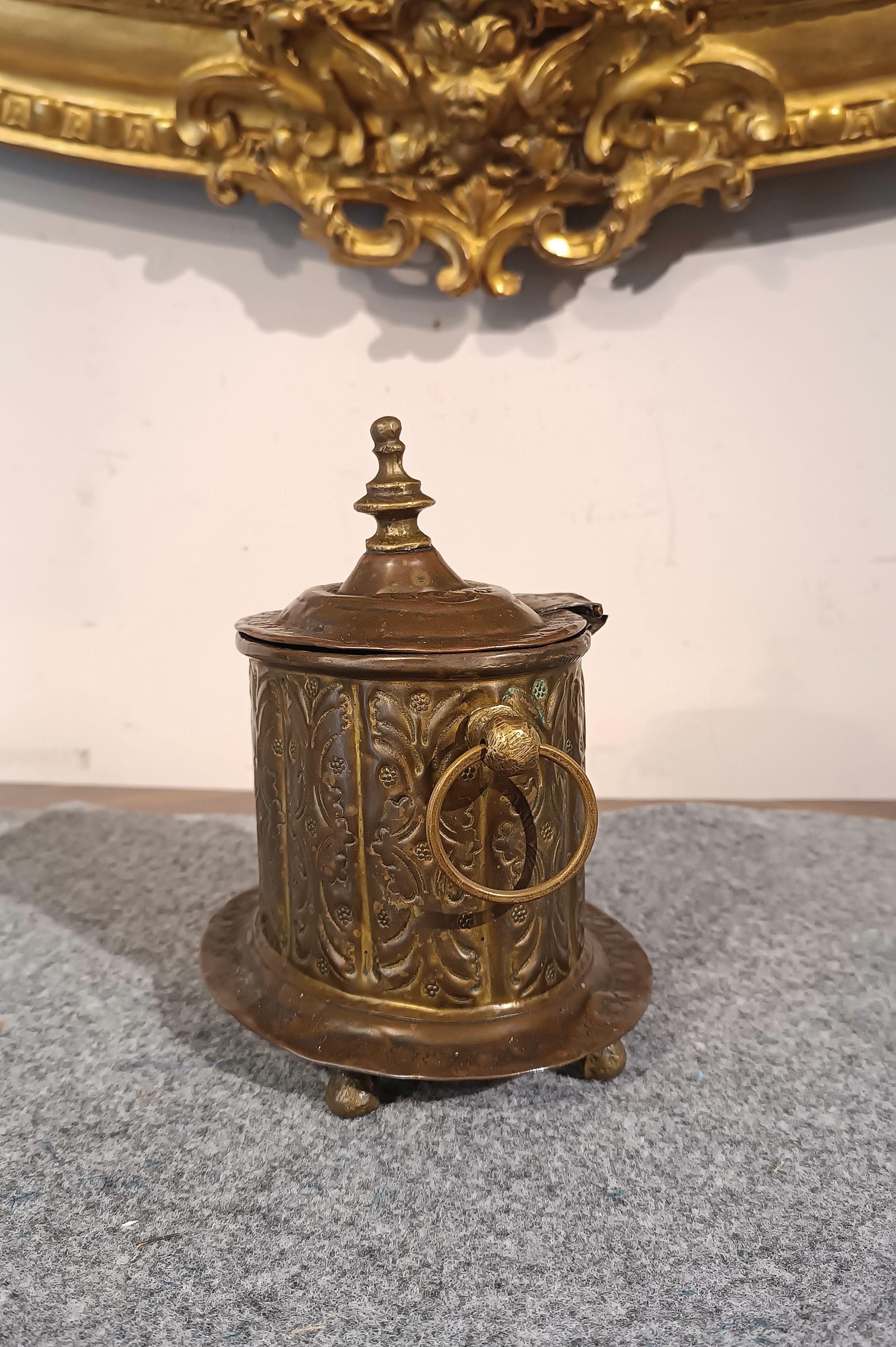Magnifique porte-essence en laiton gaufré à la main avec extrémités tournées. Le couvercle peut être ouvert pour insérer des essences, tandis que le corps est décoré de motifs végétaux en relief, ce qui confère à l'objet une élégance raffinée. En