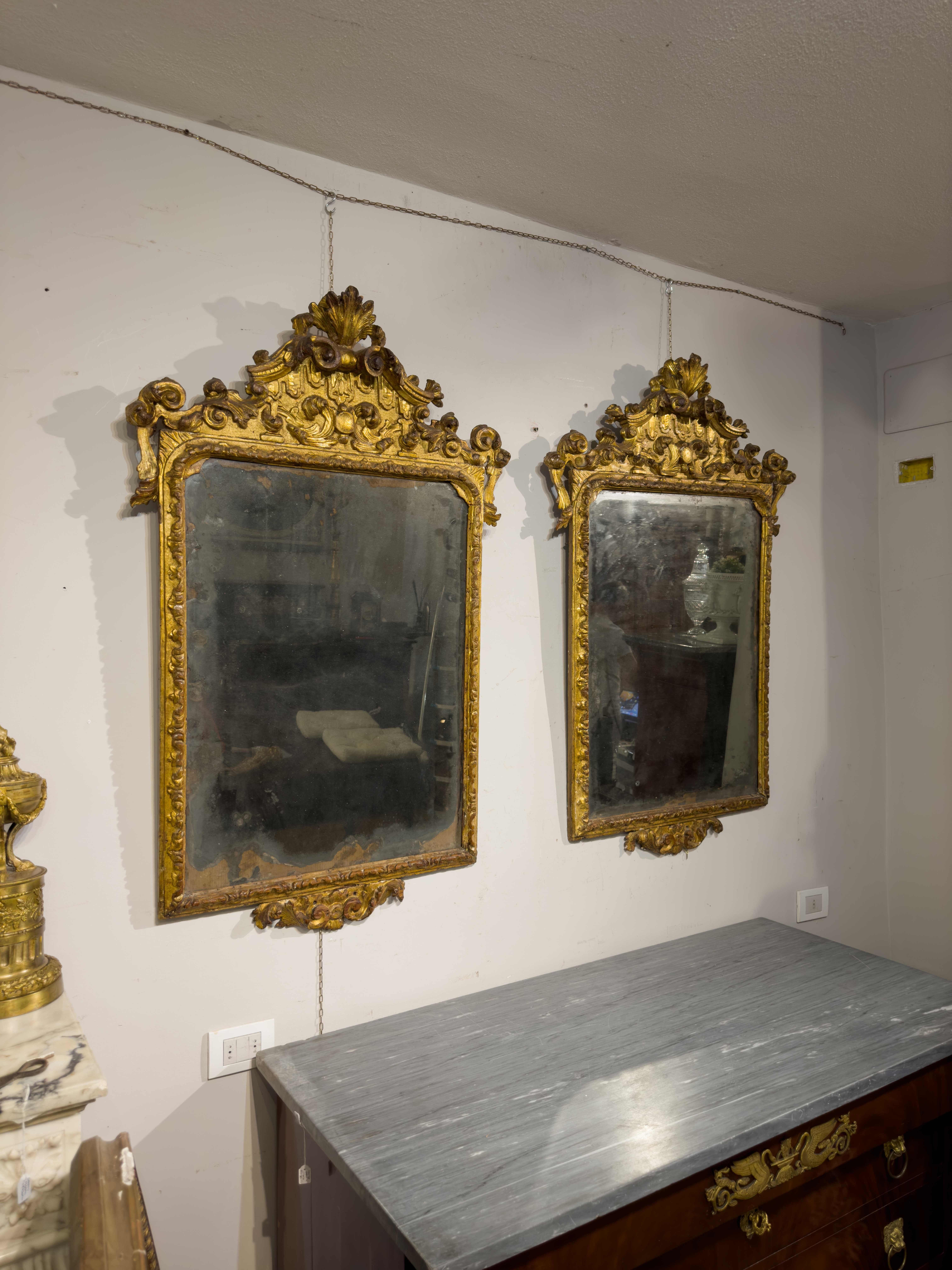 These mirrors in carved and gilded pine wood and made in the Marche region around the first half of the 18th century, represent an elegant expression of the craftsmanship of the time. The carved details reflect the artist's craftsmanship, lending a