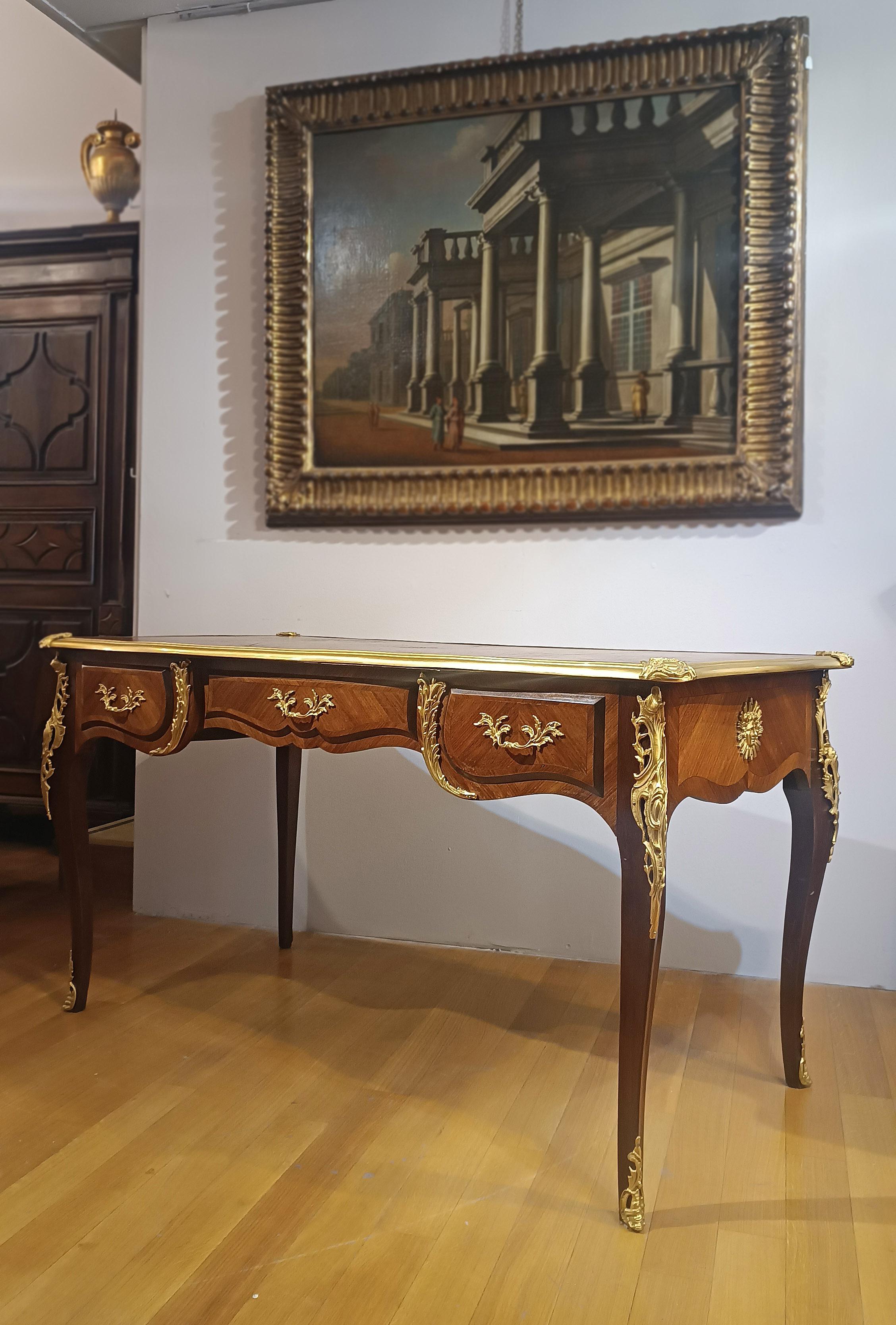 Elegant presidential desk entirely veneered in walnut, embellished with gilded bronze trim and handles. The gilded bronze trim, featuring splendid gilding, further enhances the refinement of this desk, as do the band surrounding the top, the vegetal