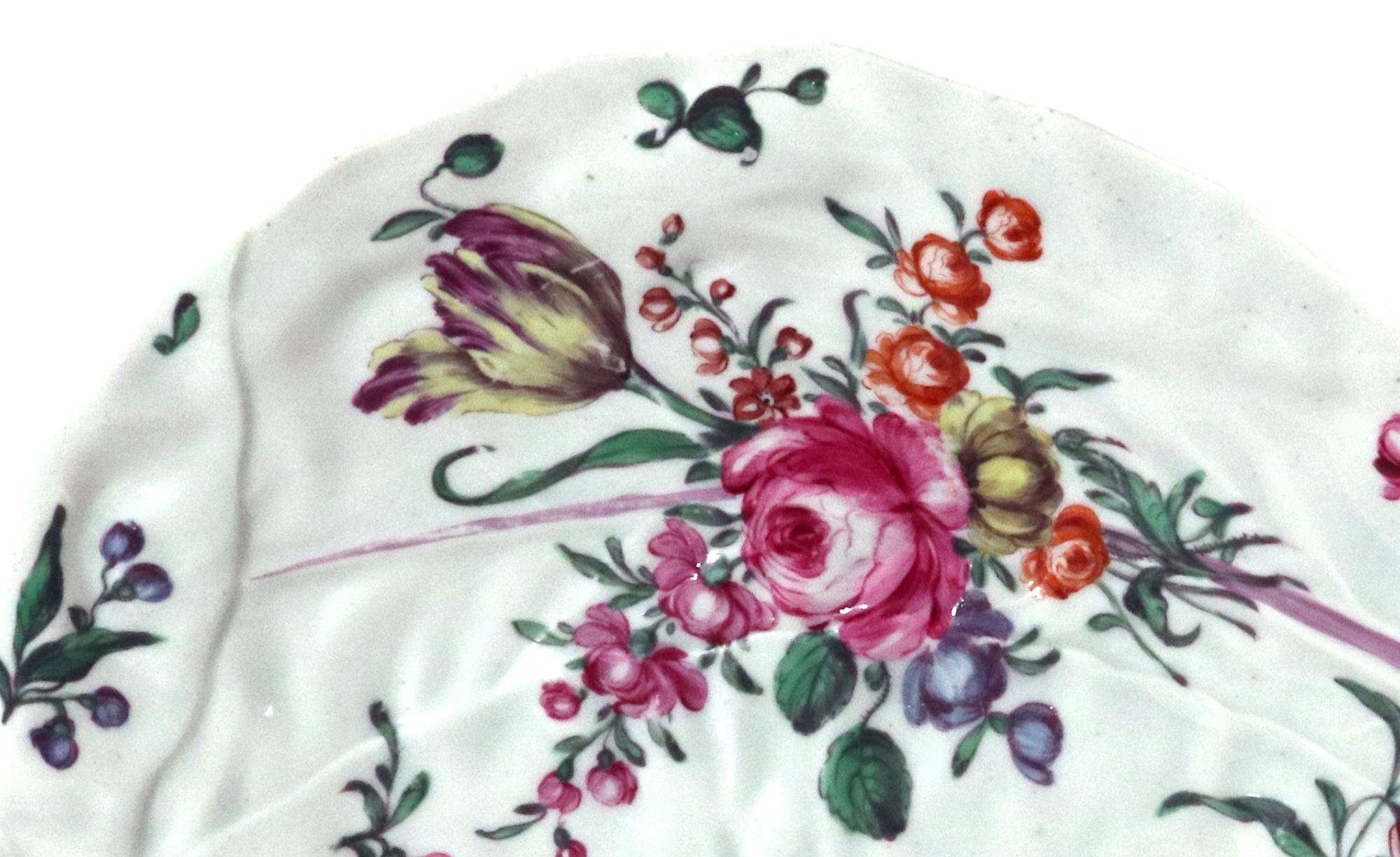 First Period Worcester botanical leaf dish,
Circa 1760

The First Period Worcester botanical leaf dish with two large molded leaves with purple veins and painted with a botanical bouquet and scattered flowers. 

Dimensions: 10 inches long x 7