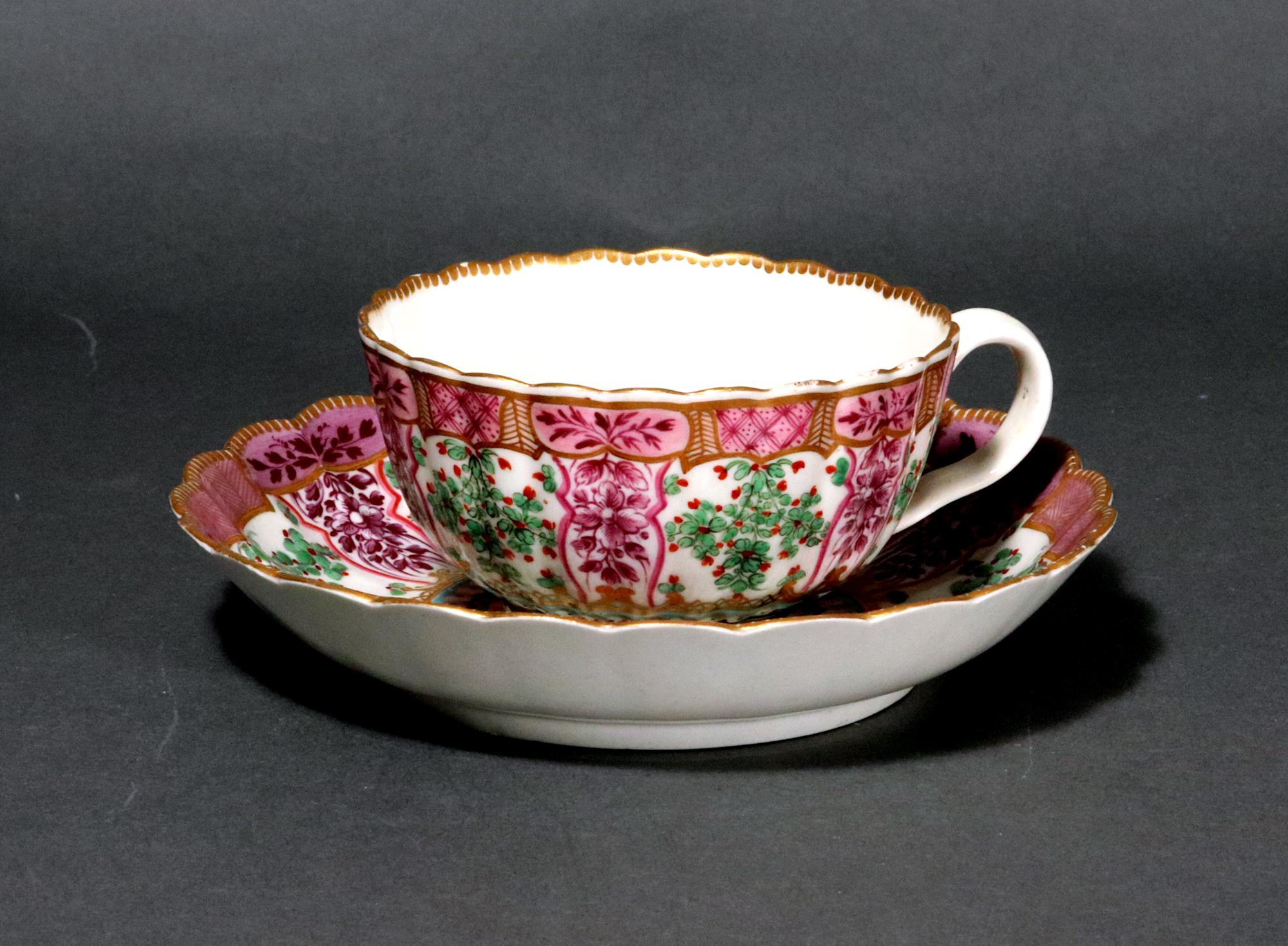 Erste Periode Worcester Porzellan Holly Berry Pattern Teetasse und Untertasse, Hop Trellis Pattern, 
Circa 1775.

Die Teetasse mit Untertasse aus Worcester-Porzellan aus der Ersten Periode hat eine geriffelte französische Form und ist reich mit dem