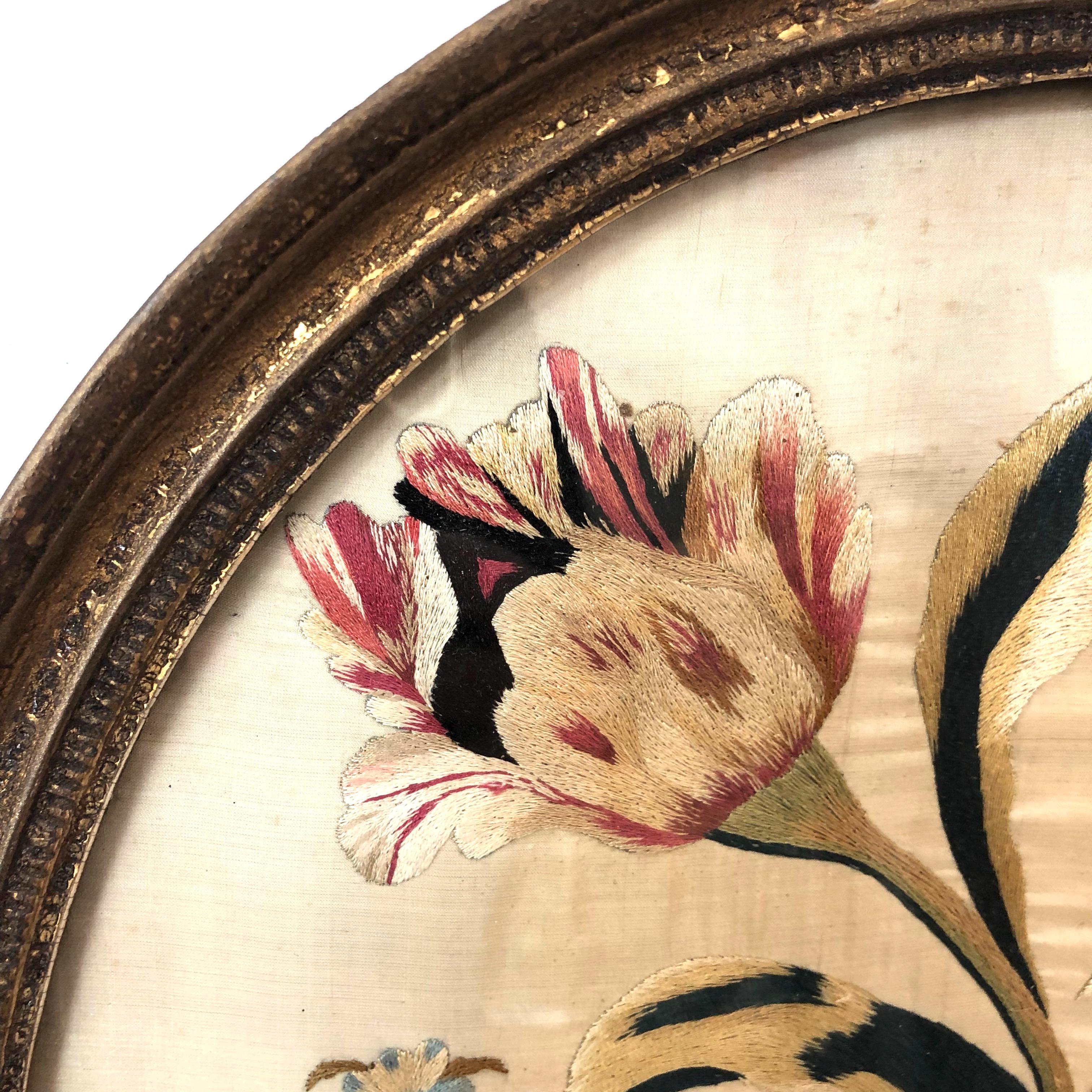 First quarter of the 19th century oval floral embroidery in original framing.