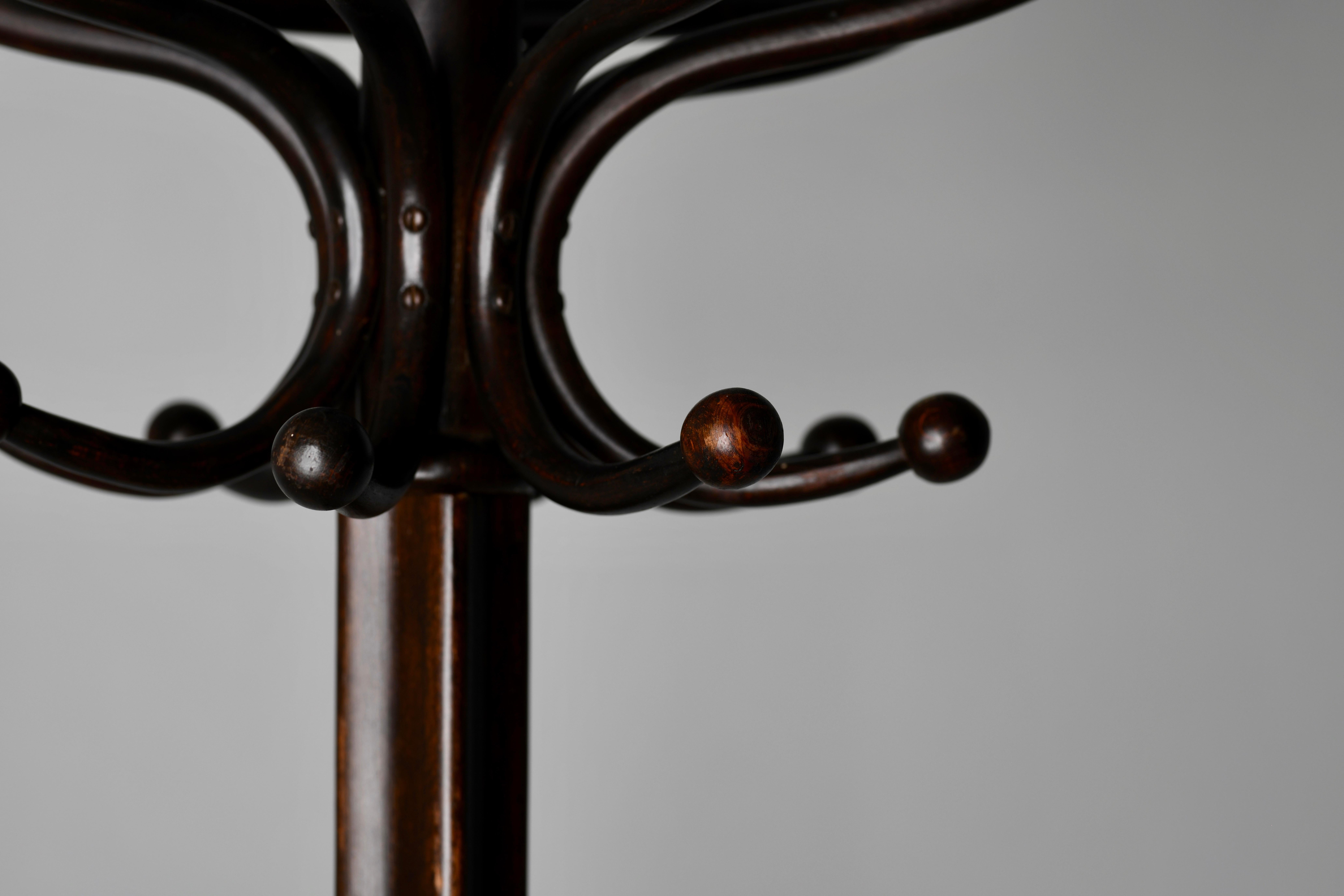 'Fischel' steam bentwood coat tree in the Secessionist School. This period example still retains the original paper label. Eight arm top, swivels to facilitate hanging and accessing your garments. Wonderful original condition.
The base has four