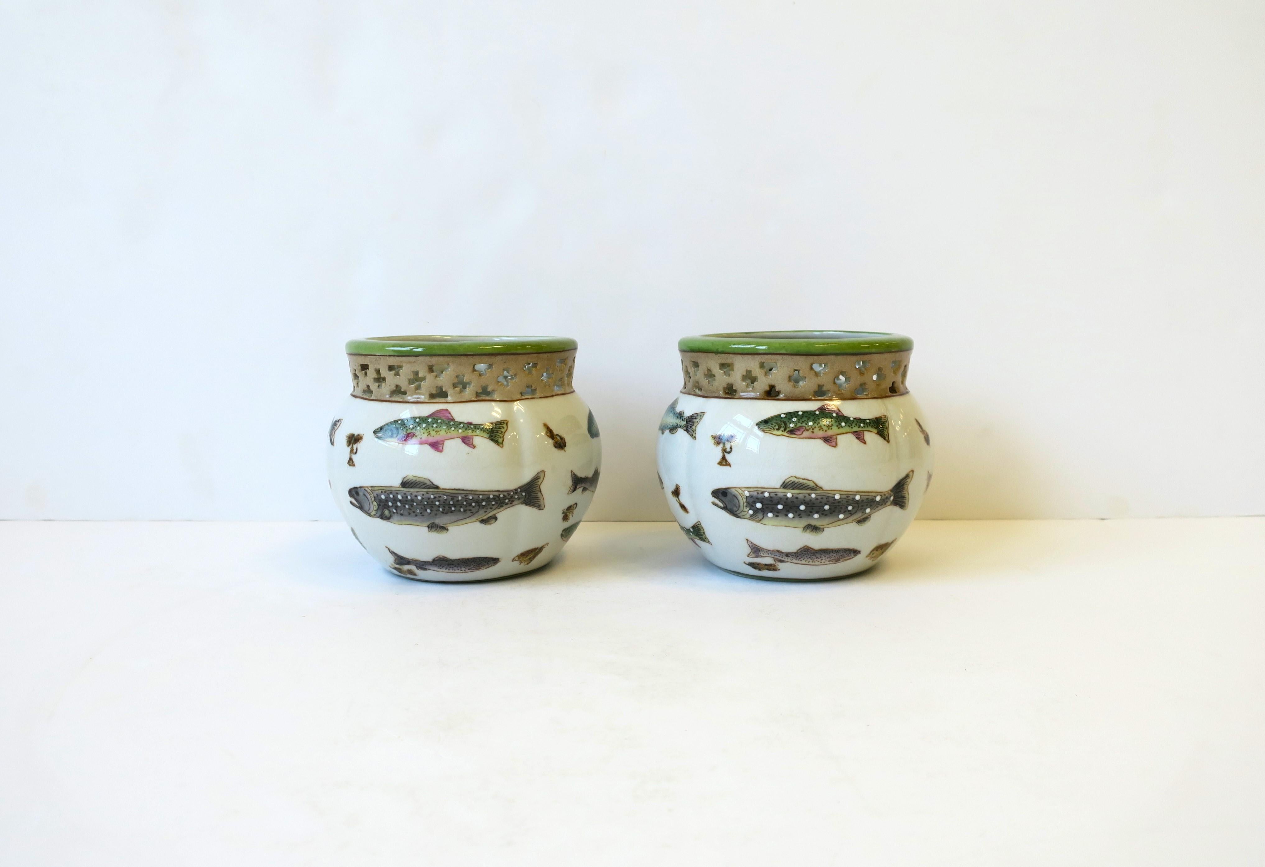 A great pair of ceramic plant or flower planter pots cachepots jardinières with fish and lure design, circa late-20th century. In the Rustic Adirondack style. Bass fish and other fish, and lures in between, surround cachepots. 

Dimensions: 4.5