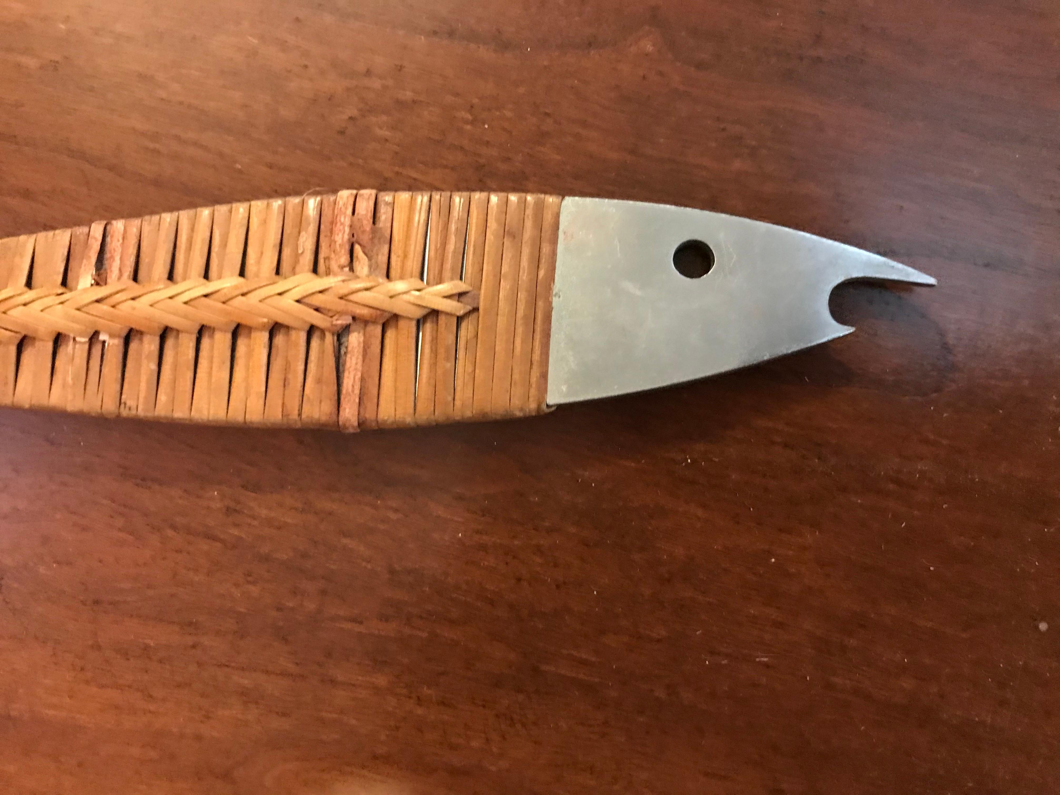 This piece in the shape of a fish, is made of polished stainless steel and cane.

Carl Auböck (also Auboeck) is the name of members of the Auböck family, who owned and managed the Vienna-based Werkstätte Carl Auböck. The workshop, which was part of
