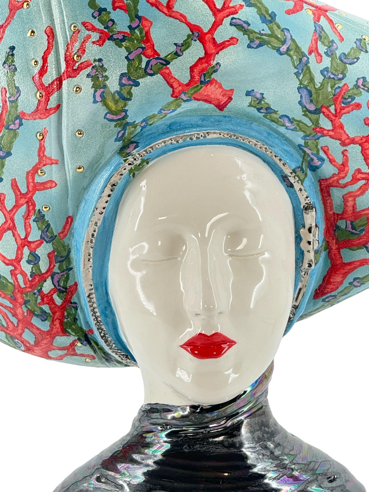 La dame de mer rouge et or s'inspire de nombreuses réminiscences culturelles de l'Italie. Des coraux inspirés de notre mer Méditerranée, des éléments dorés pour un art de luxe. Un doux visage de réassurance embellit la statue. Tout est fait à la