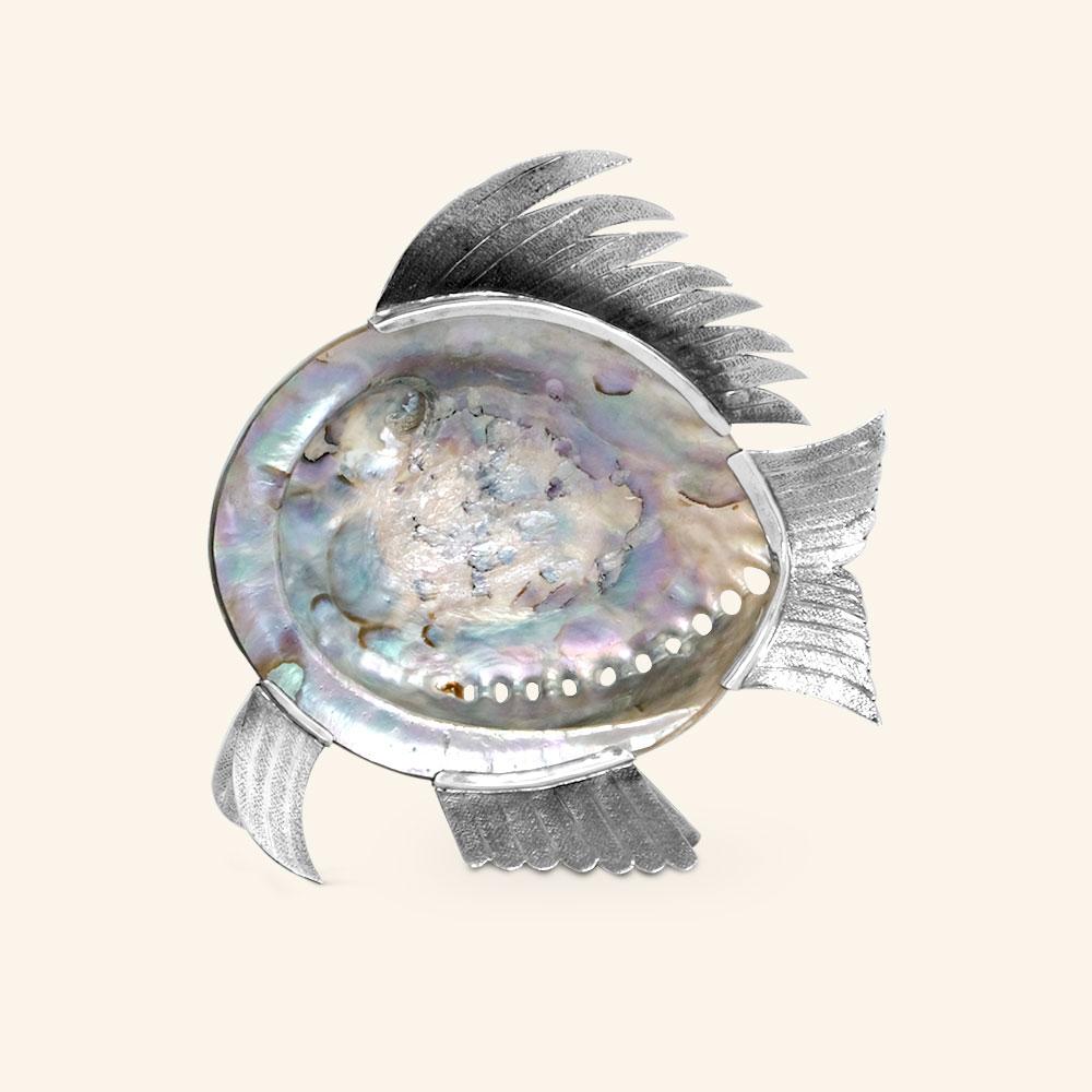 Fish with mother-of-pearl shell and eye of the tigerstone.

This fish is a contemporary sculpture made of chiseled silver plate applicated to the natural mother pearl shell, is totally handcrafted, hammered by excellent craftsmen, giving this piece