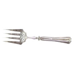 Fish serving fork in cut silver with grooves along the handle and four prongs
