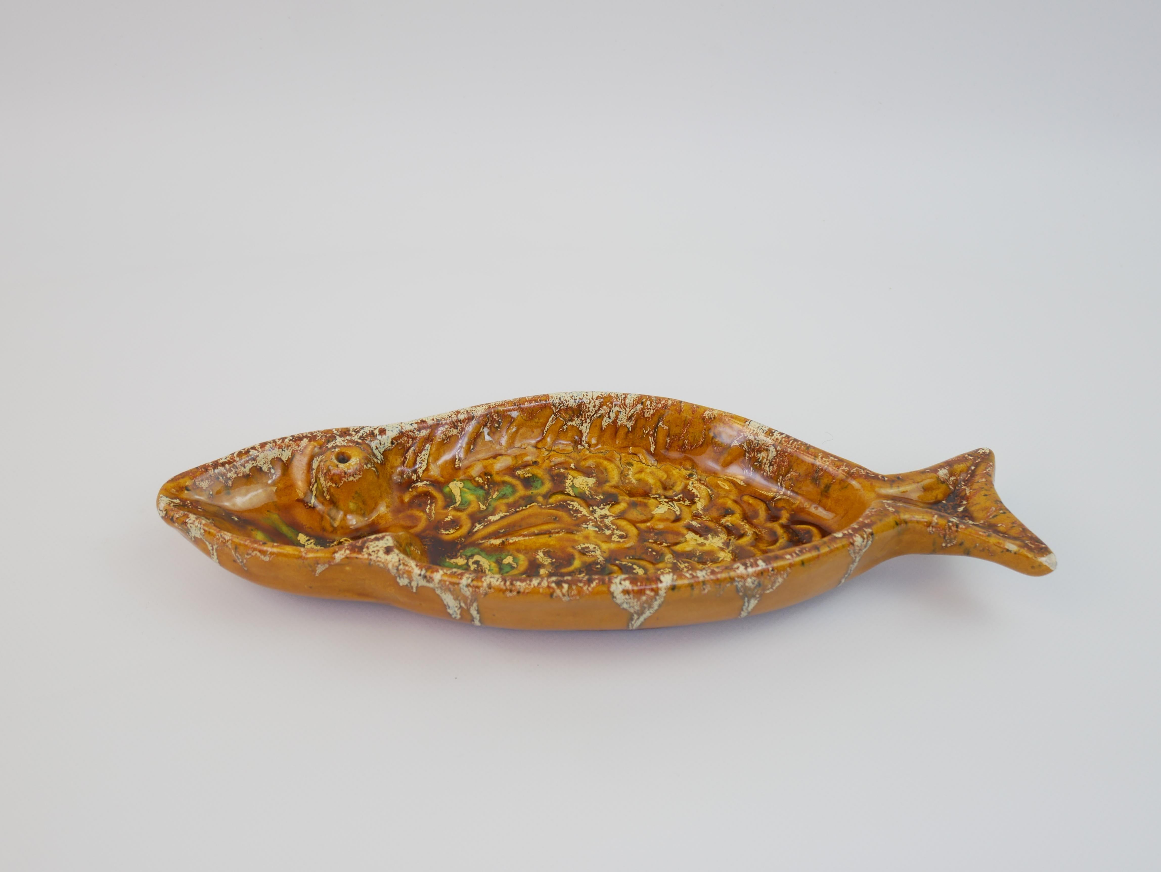 Il s'agit d'un plat ou d'un porte-bijoux en céramique datant du milieu du 20e siècle et provenant de Vallauris, ville réputée pour sa tradition potière. En forme de poisson, cette pièce date des années 1950 et illustre le style caractéristique de la