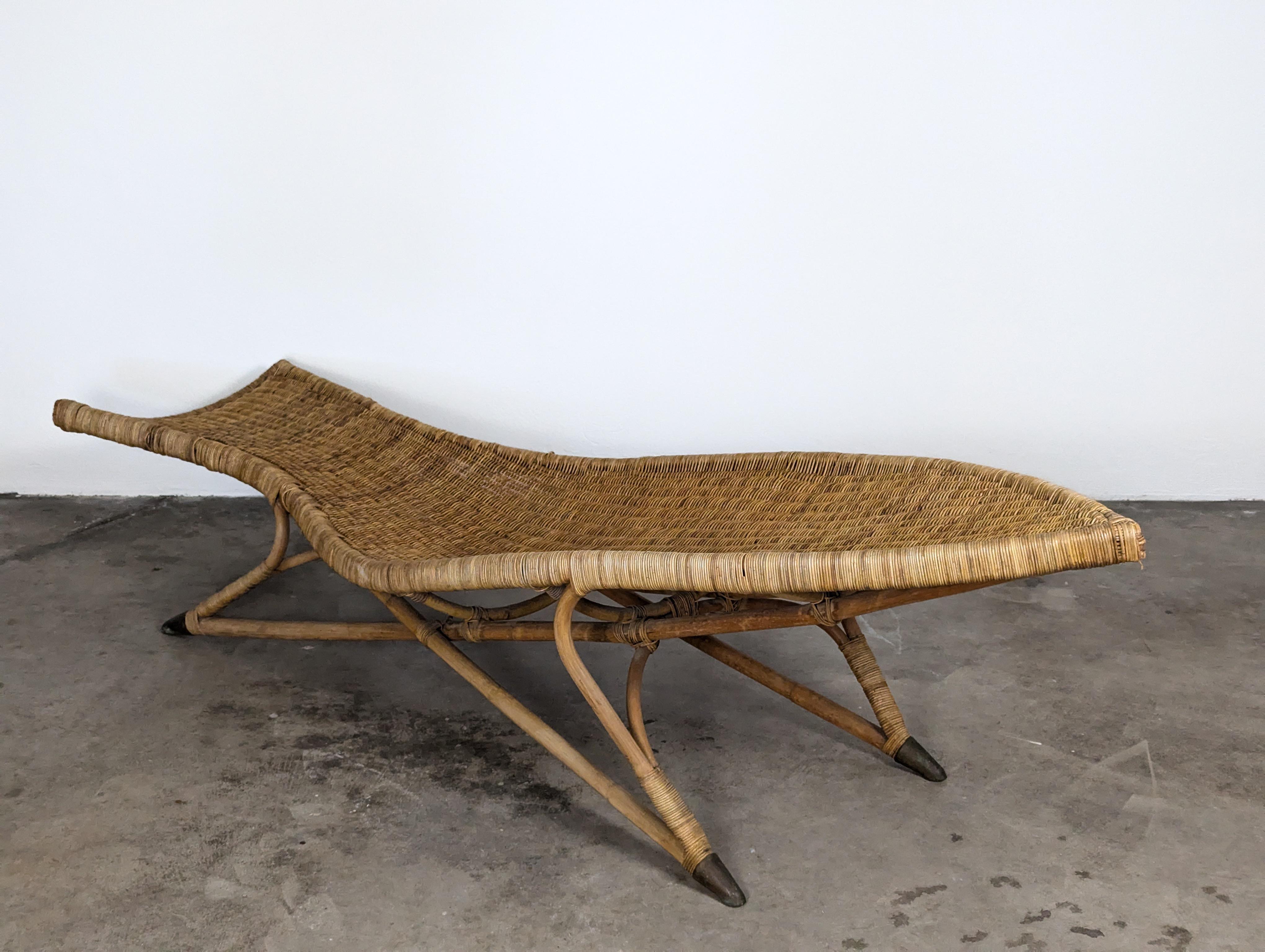 For sale is a stunning vintage fish-shaped wicker lounge chair attributed to the renowned designer Lina Zervudaki. This exquisite piece features an elongated, dainty shape, allowing you to relax in unparalleled style. The chair's sculptural base is