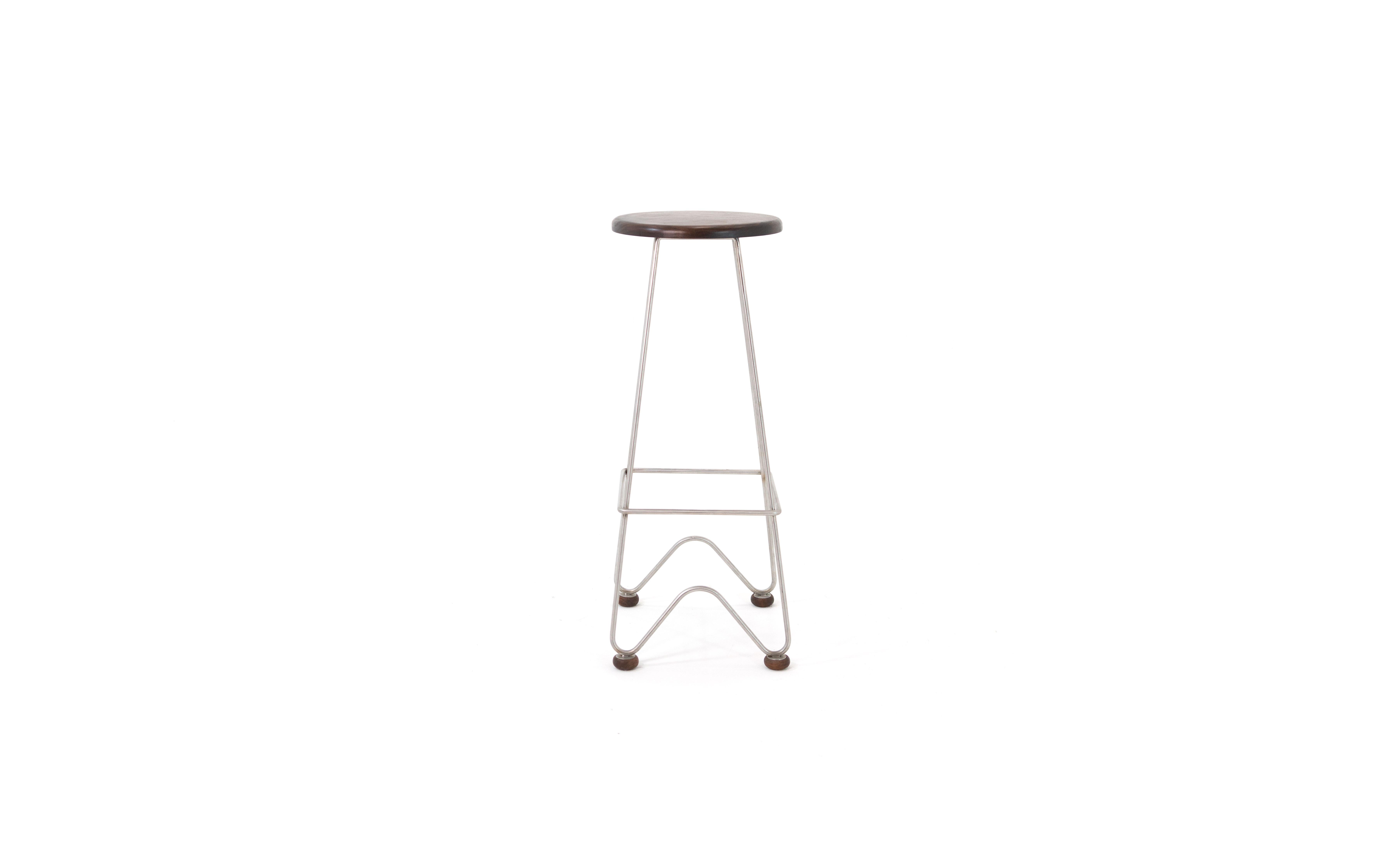 The fish stool is a high bar stool featuring hand-bent fishtail legs in stainless steel and a solid wood seat. The stool rests on solid wood castors to protect the floor.

This handcrafted piece is hand-oiled using house-blended oils and