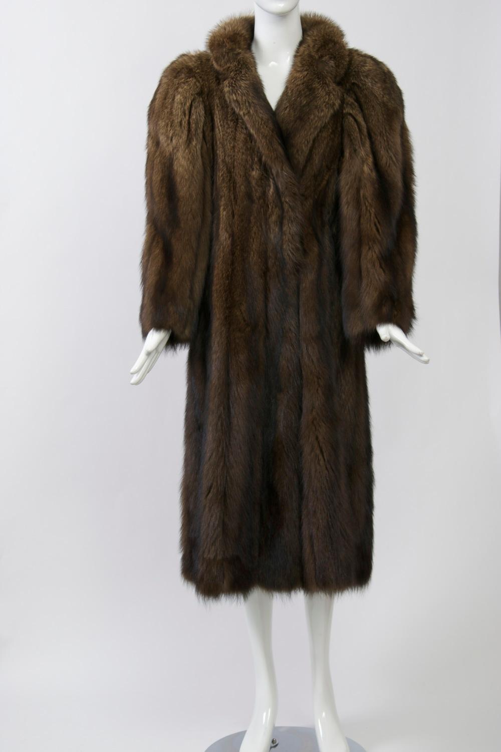Luxurious fisher coat by Alixandre, known for high quality furs. Simple styling featuring a notched collar and round, padded shoulders, the vertical skins falling to mid-calf length. Hidden side pockets, fur hook closures in front and button at neck
