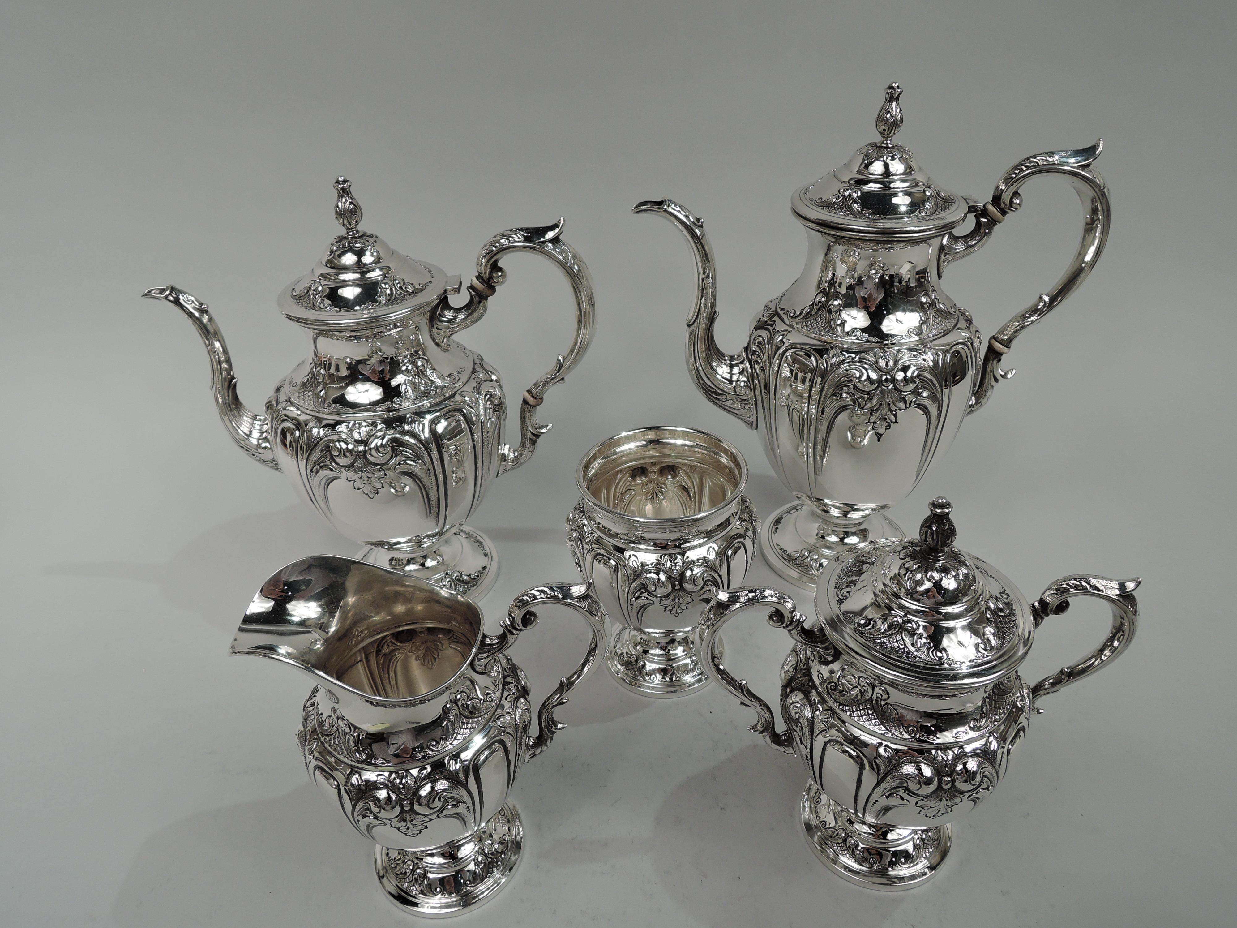 Victoria pattern sterling silver coffee and tea set. Made by Fisher in Jersey City. This set comprises 5 pieces: Coffeepot, teapot, creamer, sugar, and waste bowl. Each: Ovoid body on domed foot. Handles leaf-capped and double-scrolled. Covers
