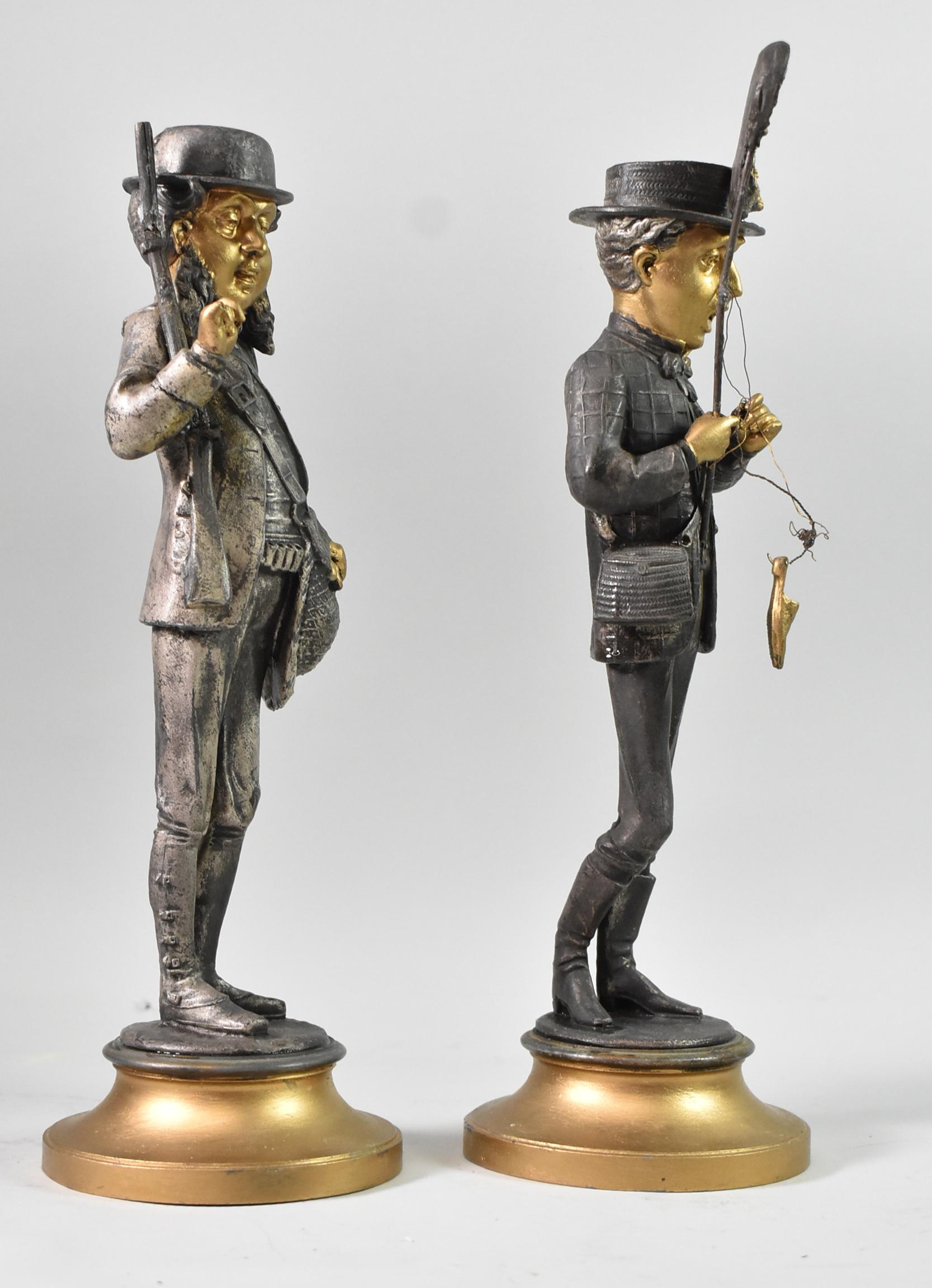 These metal candlestick holders have many gold details, including the faces, hands and bases. The fisherman features a net that is caught in his shoe and the hunter carries a rifle. Each figure stands 13