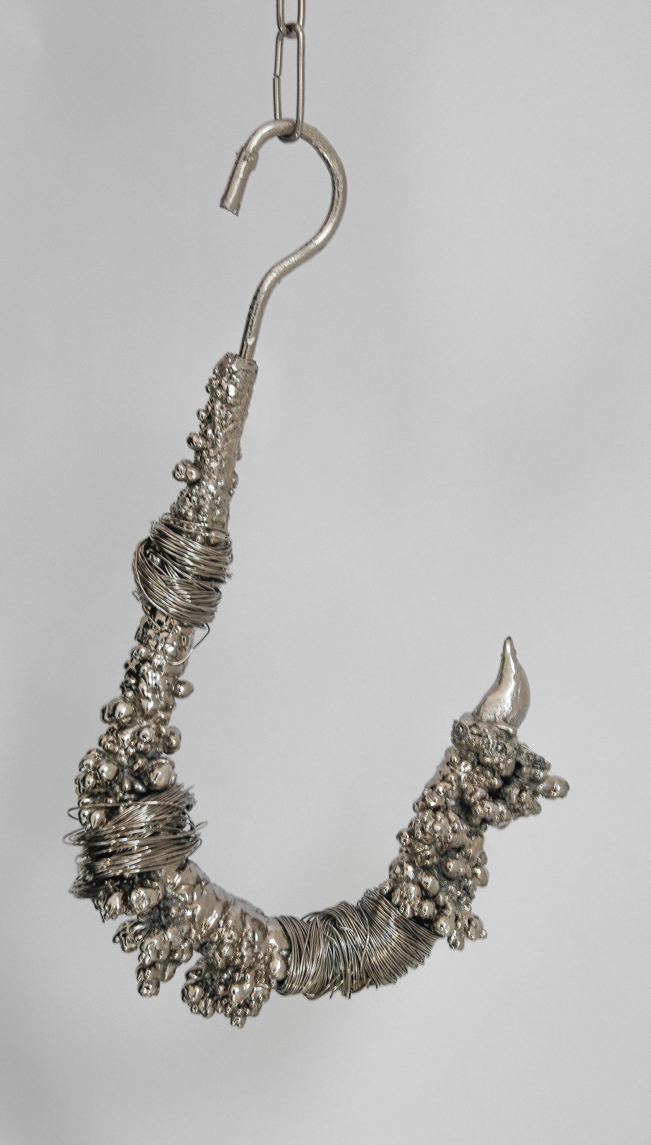 Fisherman Hook fait partie d'une série limitée d'objets uniques qui intègrent l'utilisation de tiges de galvanoplastie recyclées. Ces tiges, régulièrement utilisées pour immerger des pièces métalliques dans des bains de chrome, accumulent au fil des