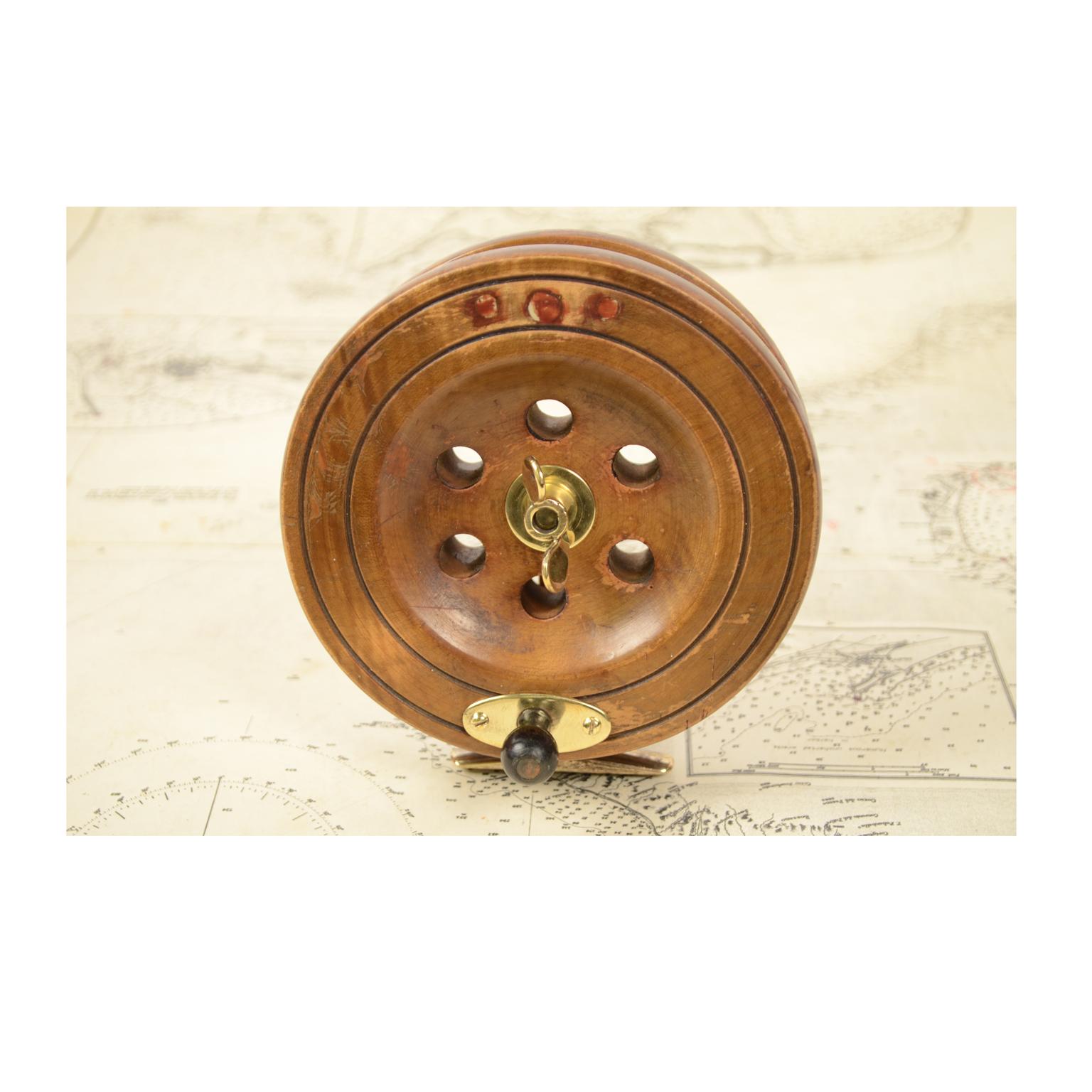 Fishing reel of turned oak and brass, English manufacture from the early 1900s. Measures: Cm 14 x 4.2.
  