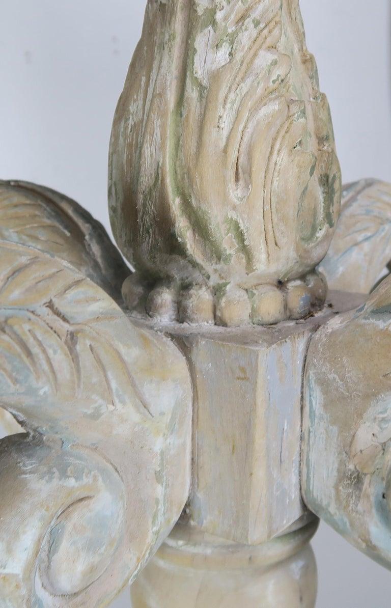 Lampadario a otto luci a due livelli in legno intagliato in stile italiano con resti di vernice. Questo apparecchio ha una bellissima finitura verniciata e usurata. L'apparecchio è stato ricablato di recente con coperture per candele di cera a