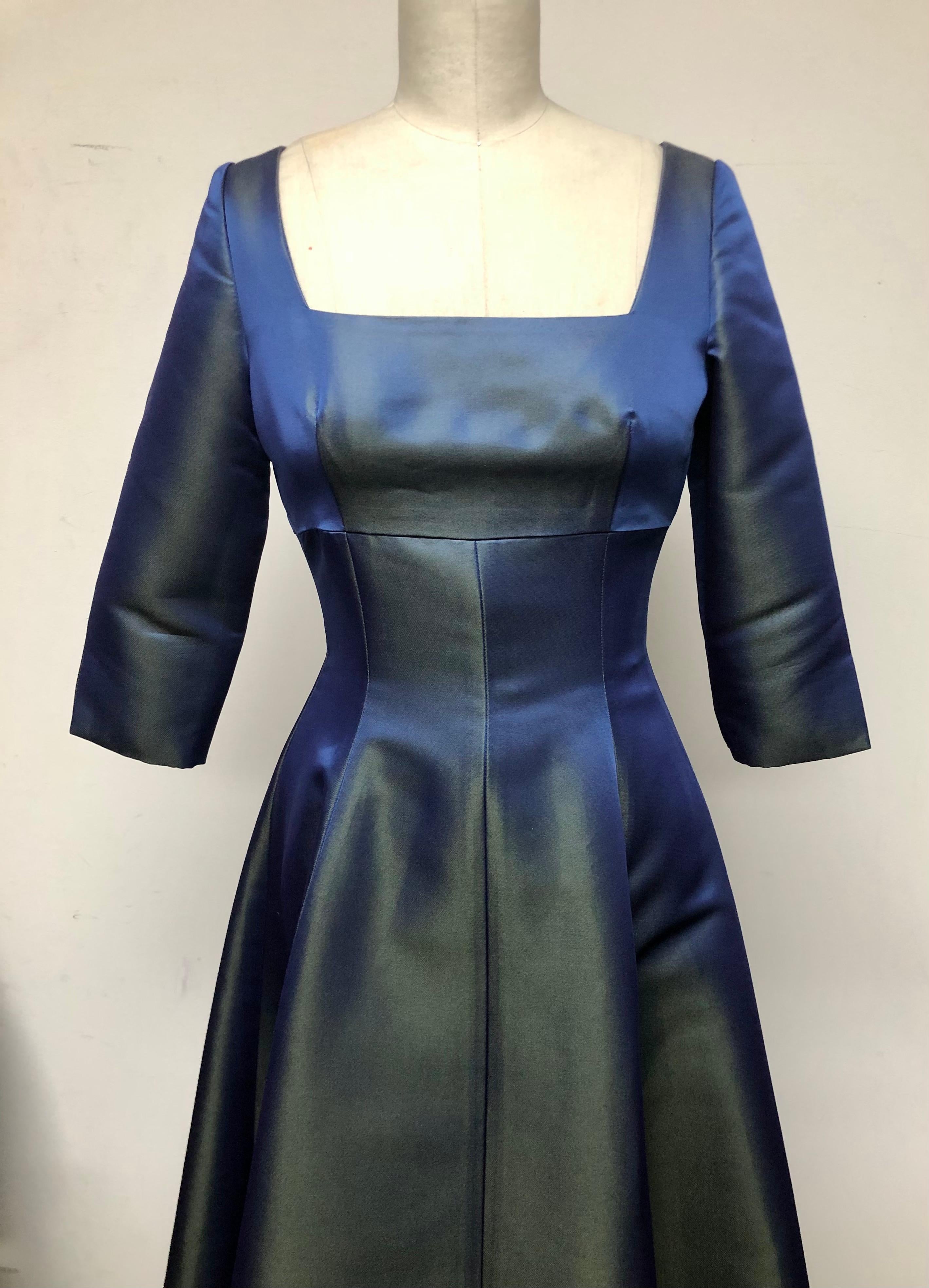 Fit and flair dress with square-neck, 3/4 length sleeve. Originally designed for and worn by Adele. Great for holiday parties and dancing—a true party dress. Iridescent fabric in blue and green heavy satin gives a festive feel. Shown in New York
